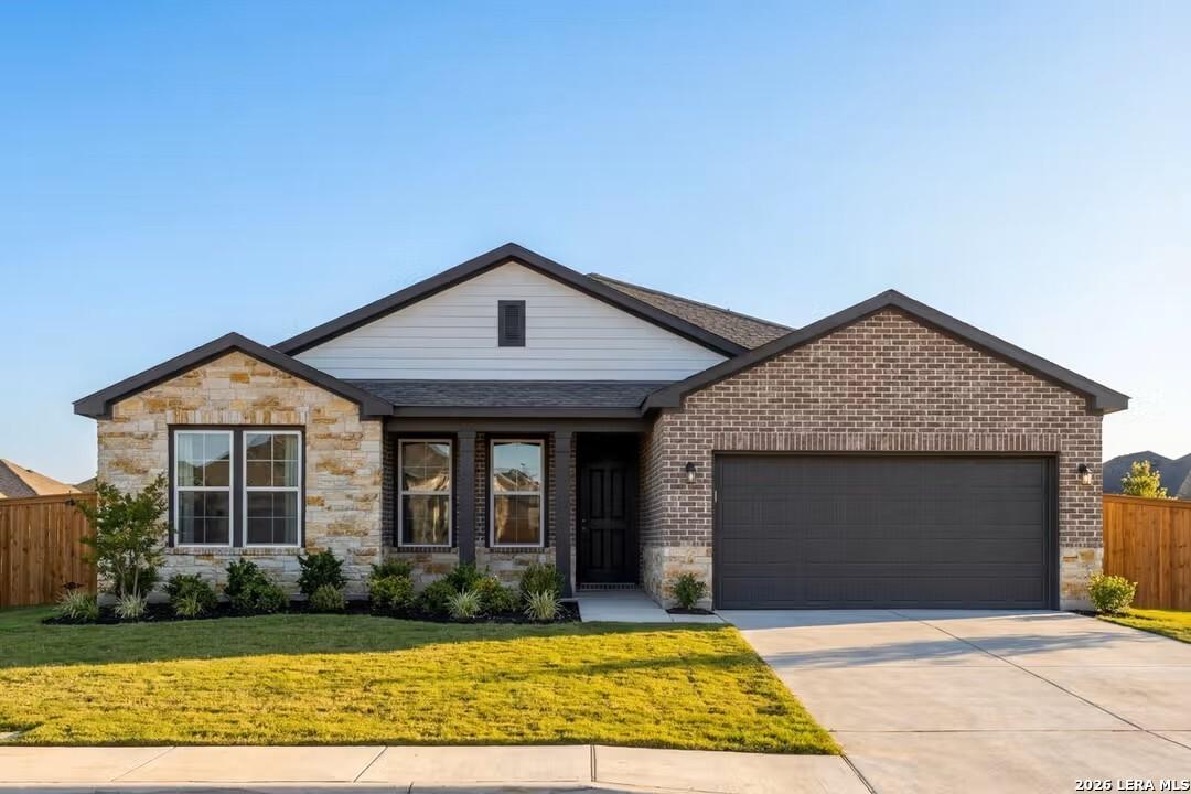 Modern 1-story Davidson Homes Rockford F with brick-stone facade, 2-car garage, and landscaped yard in The Reserve at Potranco Oaks, Castroville, TX