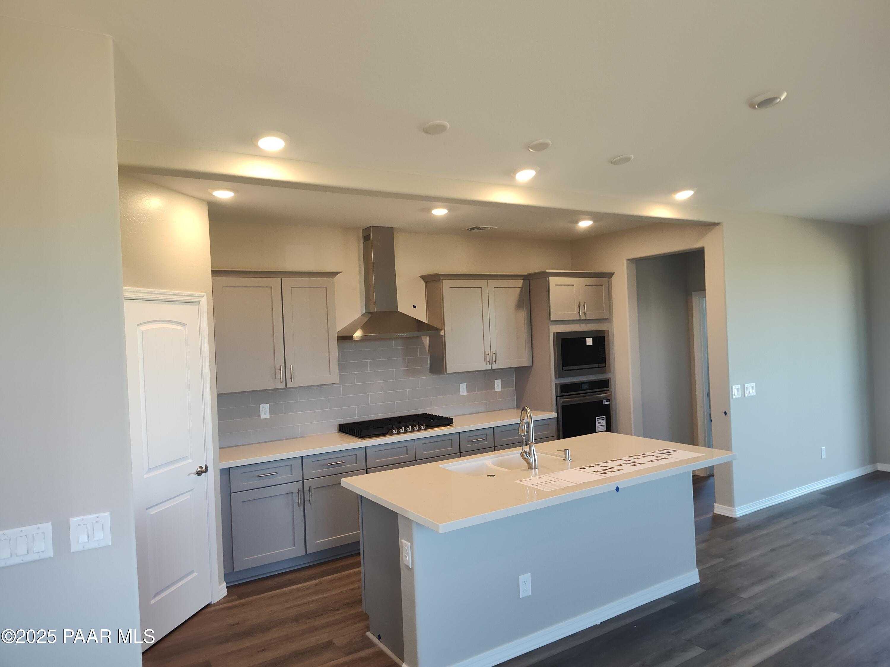 Modern kitchen featuring large center island, stainless steel range and double oven, gray shaker cabinets in Davidson Homes The Frontier A, Prescott Valley, AZ