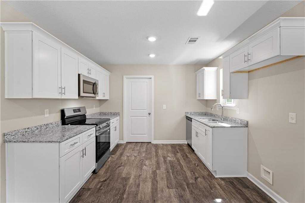 Modern kitchen featuring white shaker cabinets, granite countertops, stainless steel appliances in Davidson Homes The Washington, Phenix City, AL