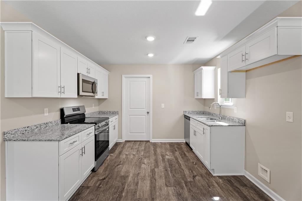 Modern kitchen featuring white shaker cabinets, granite countertops, stainless steel appliances in Davidson Homes The Washington, Phenix City, AL