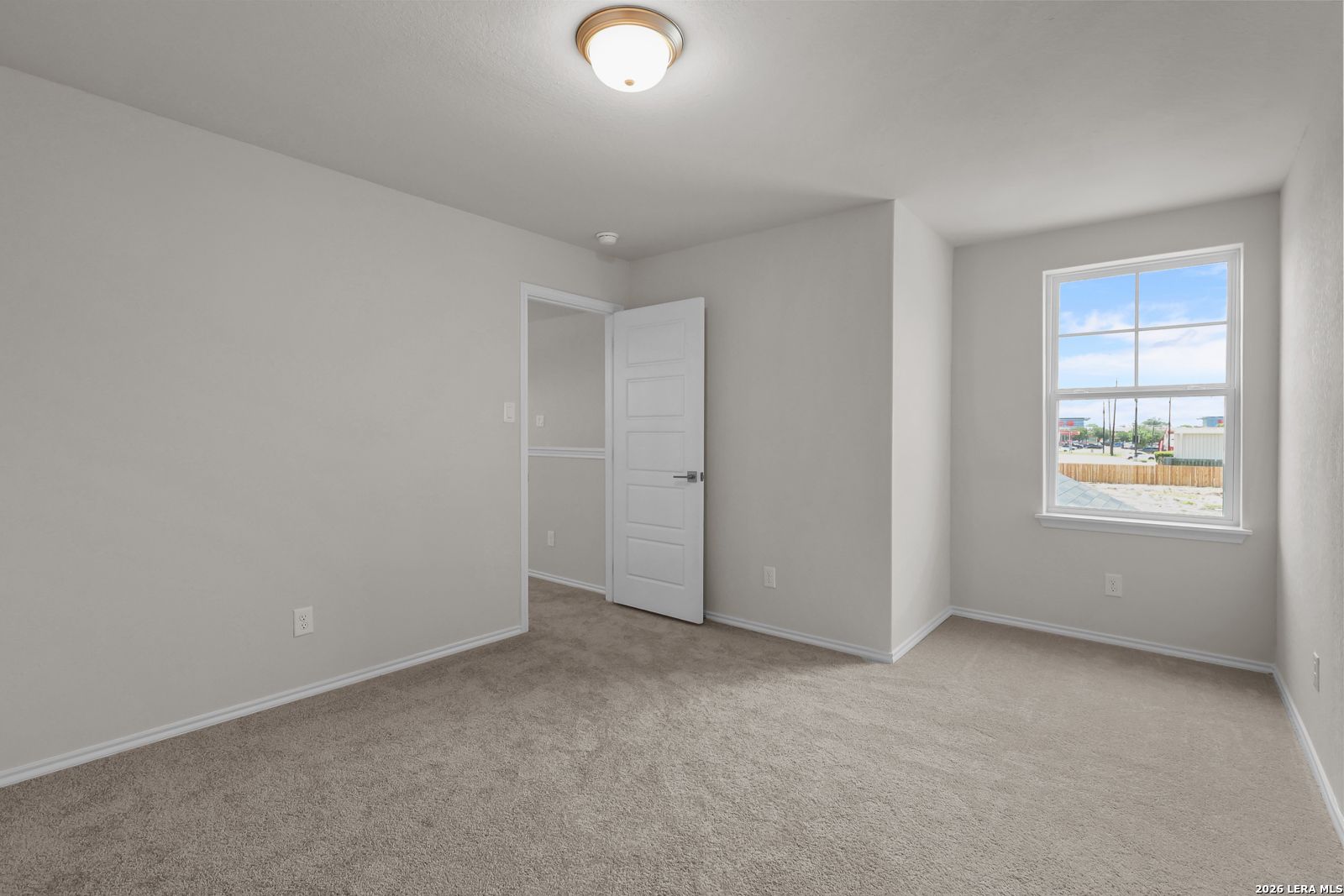 Bright, carpeted bedroom with neutral walls in The San Marcos F floor plan by Davidson Homes in San Antonio, Texas.