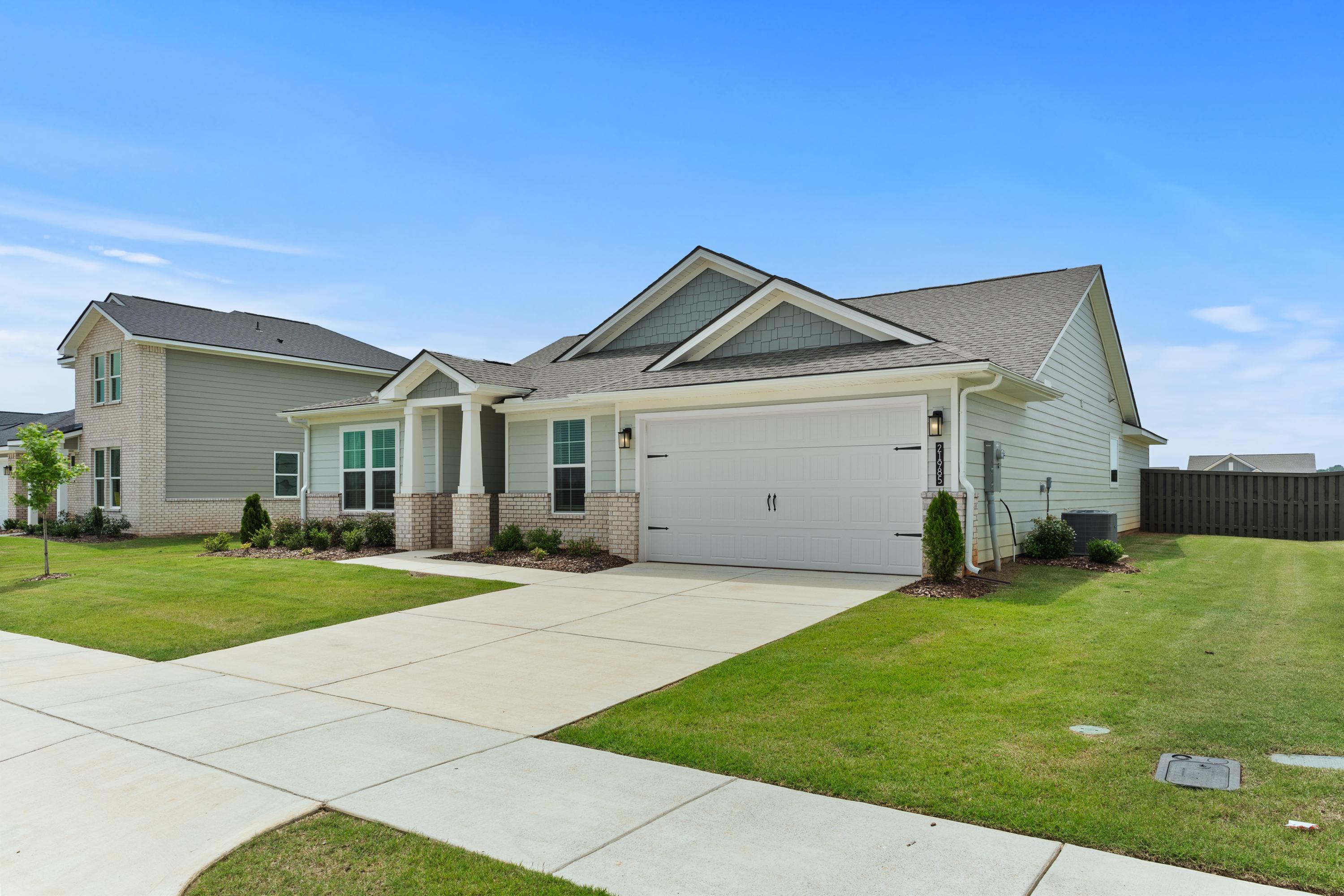 Contemporary gray craftsman-style home at Anderson Farm in Athens, Alabama with attached garage and lush front yard