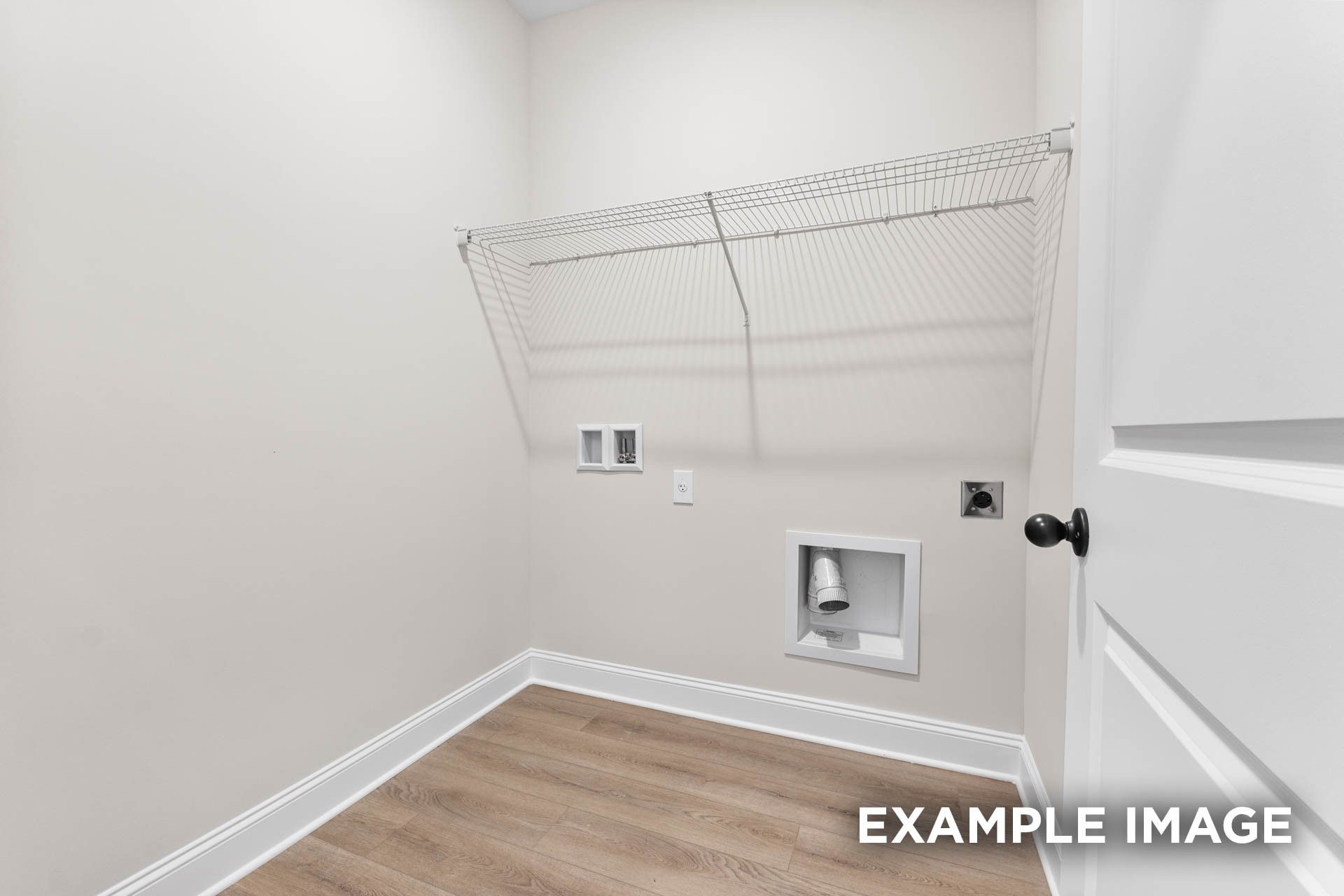 Laundry room with wire shelving and utility hookups in The Franklin E floor plan at Bailey Park, Fayetteville, Tennessee.