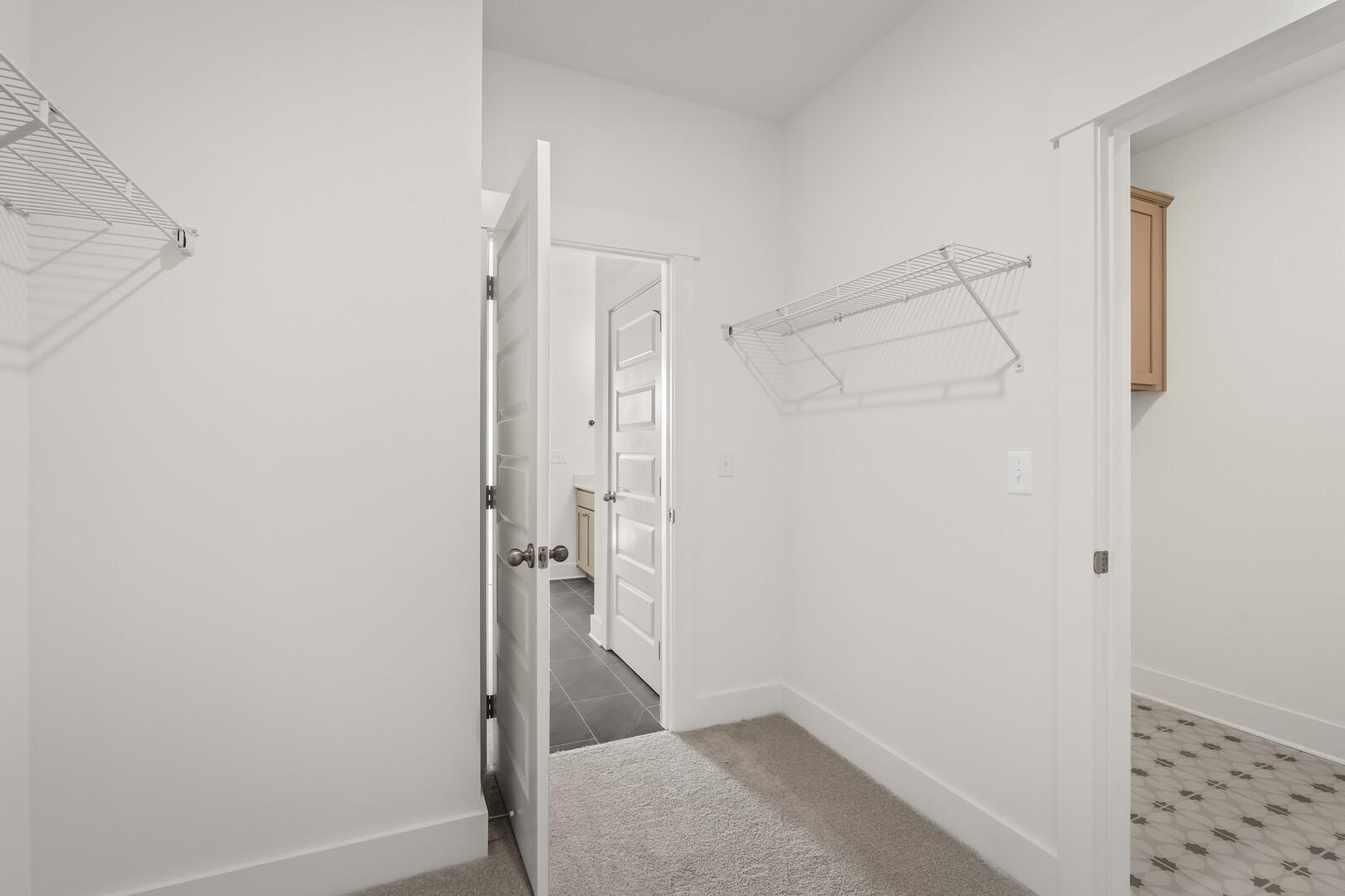 Spacious walk-in closet with wire shelving and en-suite bathroom door in Davidson Homes The Ash A, Gallatin, TN