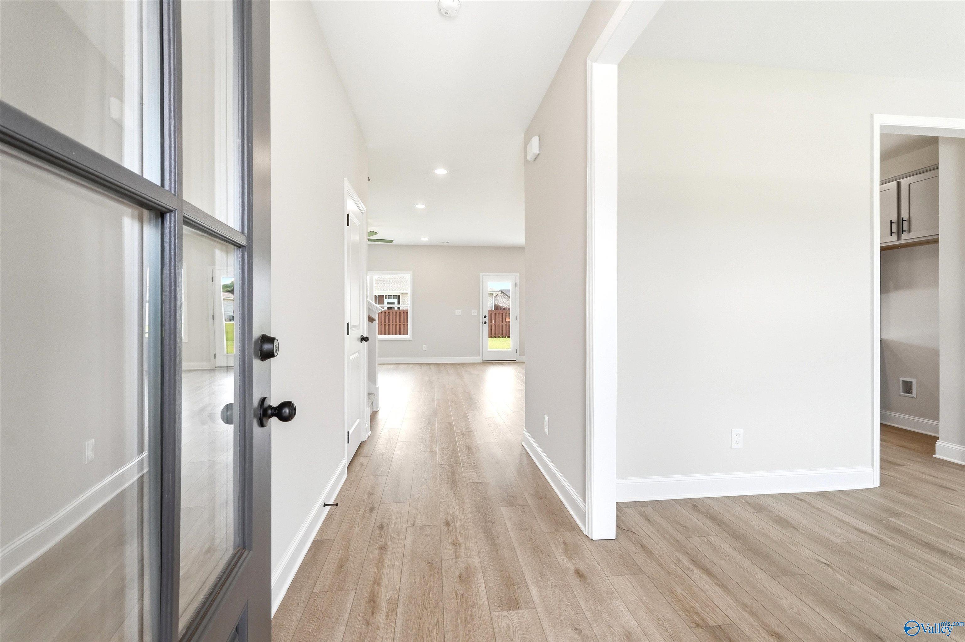 Bright open entryway with wood-look flooring in The Shelby A floor plan at Wood Trail in Toney, Alabama.