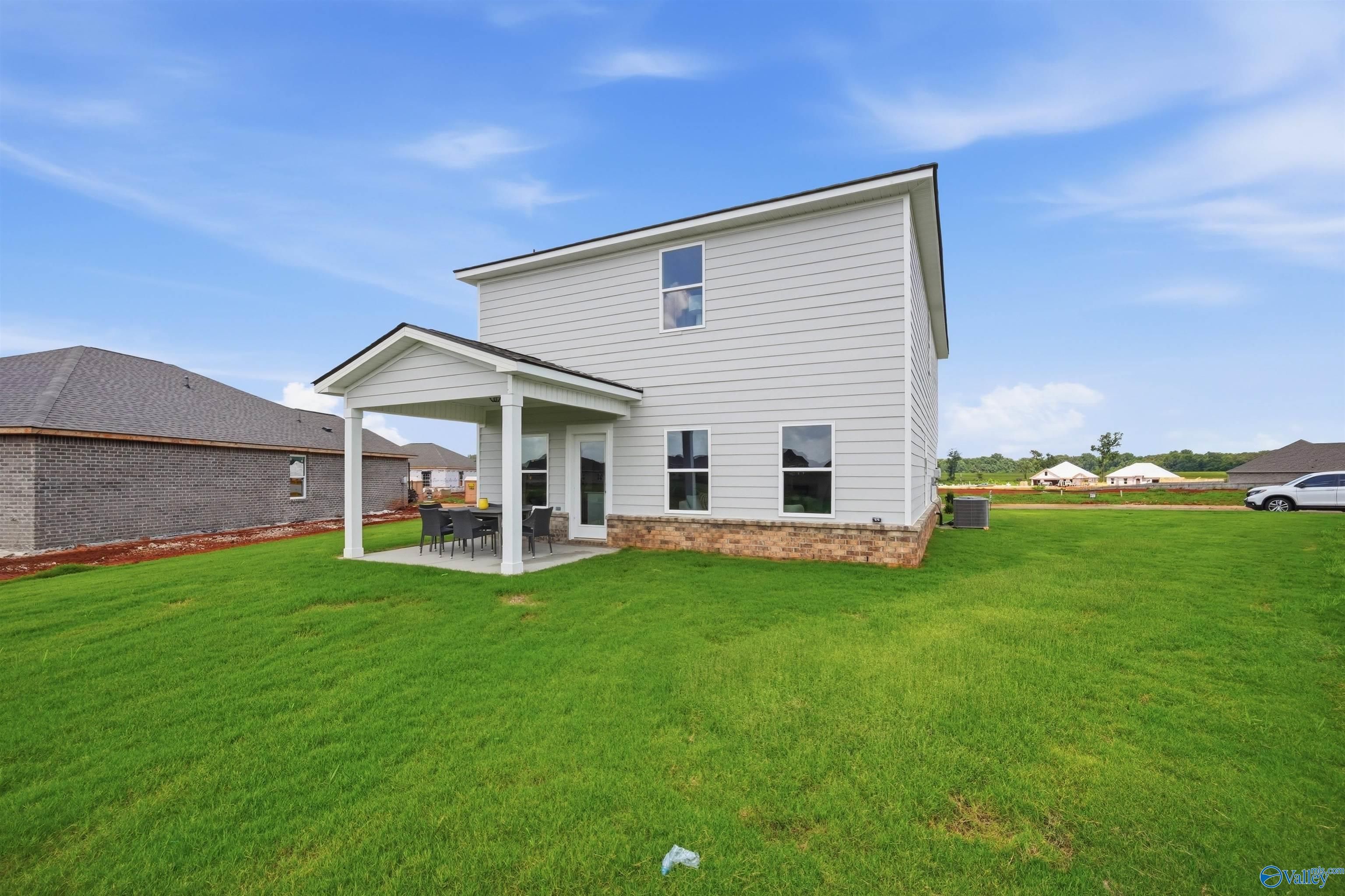 Two-story exterior of The Burton B floor plan by Davidson Homes with covered patio in Heritage Lakes, New Market, Alabama.