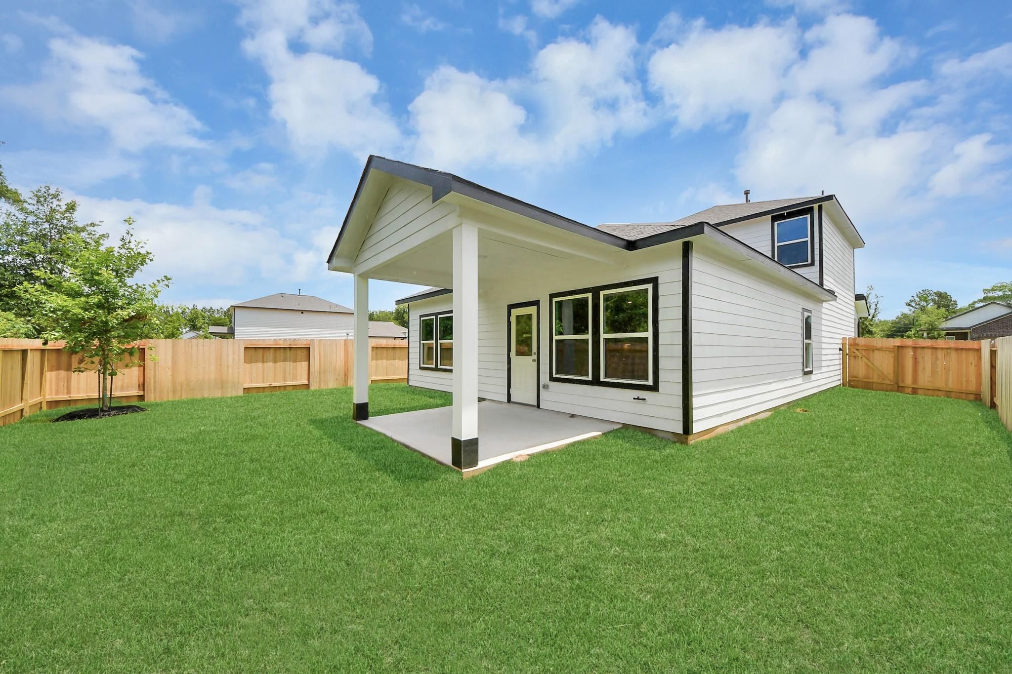 Covered back patio and fenced backyard of The Blanco E floor plan by Davidson Homes in Caney Creek Place, Conroe, Texas.