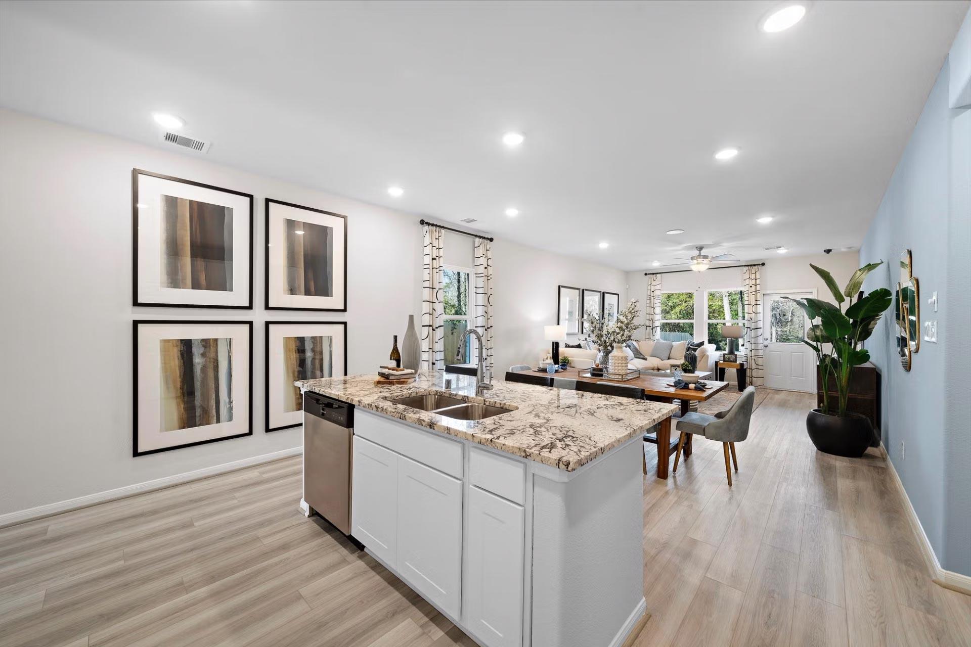 Open-concept kitchen dining area at Saddle Creek Ranch in Cibolo TX with granite island hardwood floors recessed lighting
