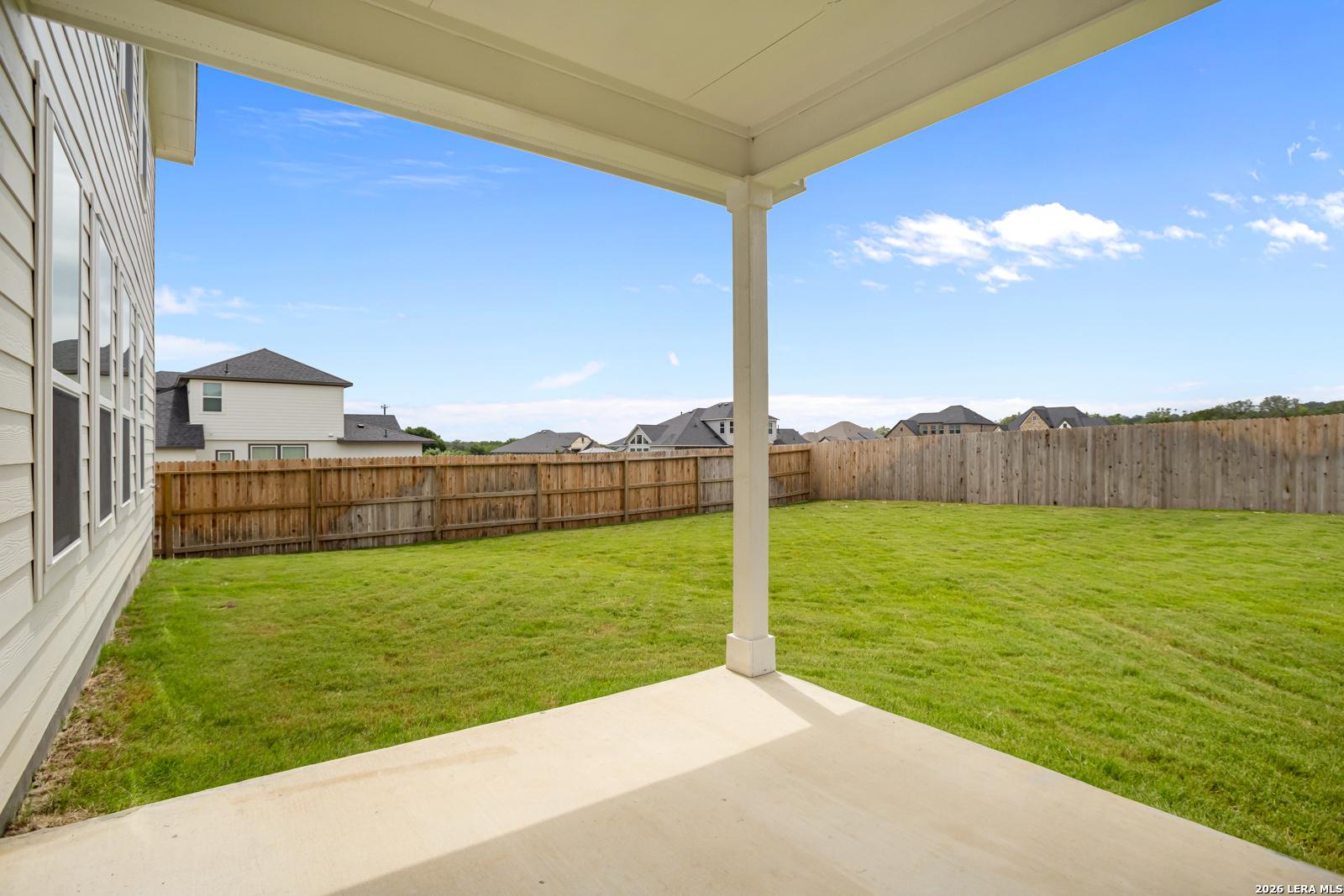 Covered back patio with a spacious fenced backyard at The Danbury H model in The Reserve at Potranco Oaks, Castroville, TX.