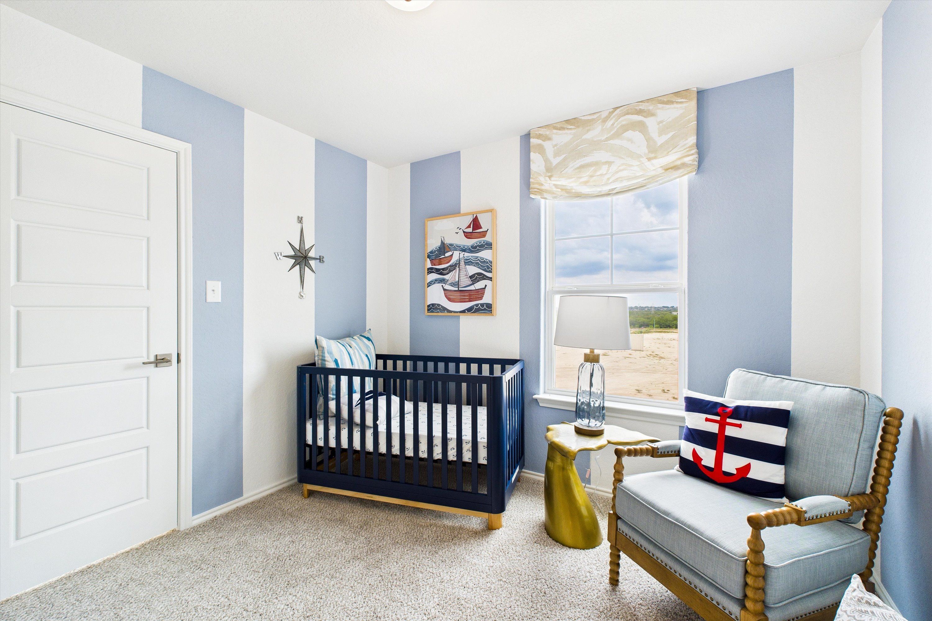 Nautical-themed nursery in Agave San Antonio TX with blue-white striped walls, crib, anchor armchair, and boat artwork