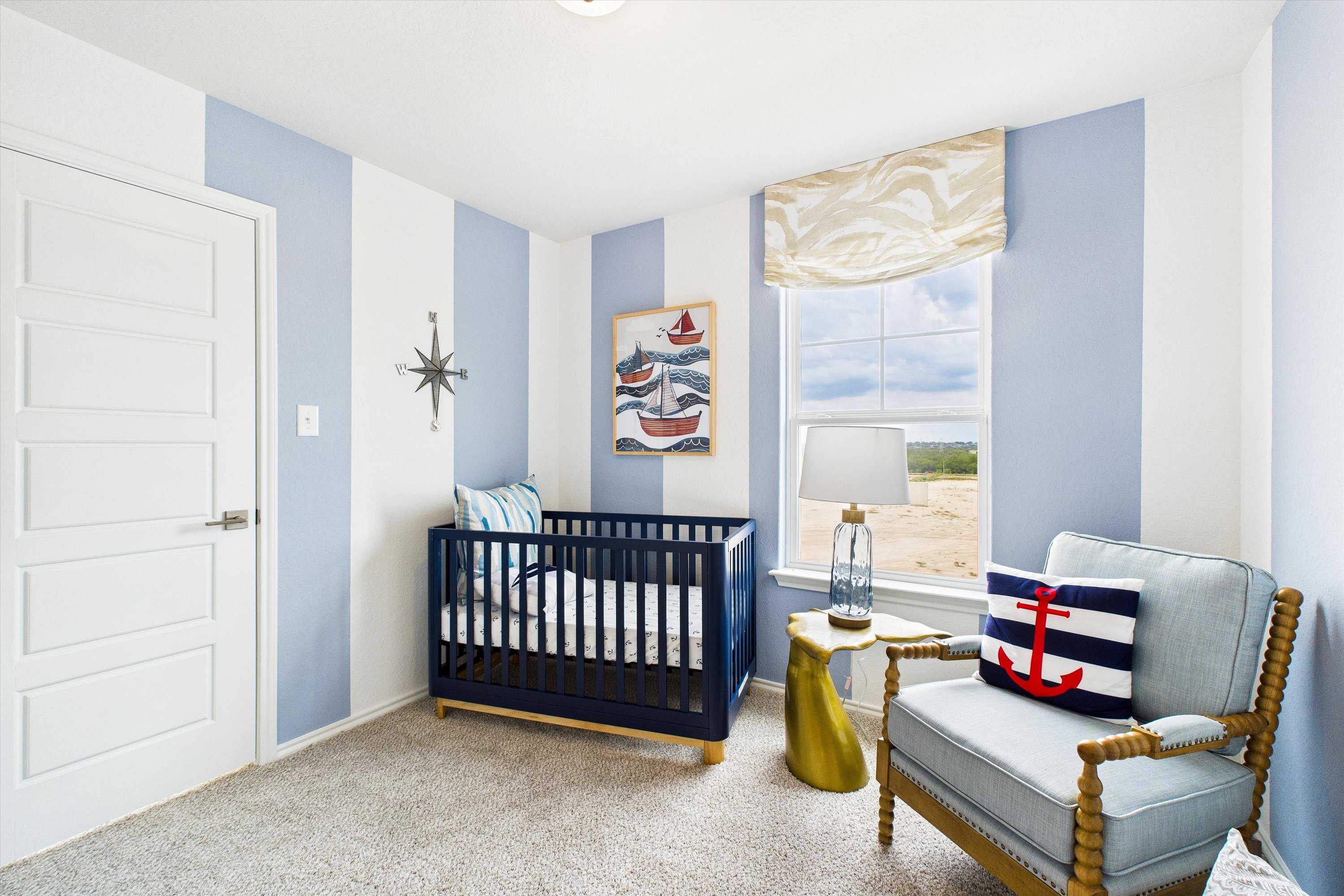 Nautical-themed nursery in Agave San Antonio TX with blue-white striped walls, crib, anchor armchair, and boat artwork