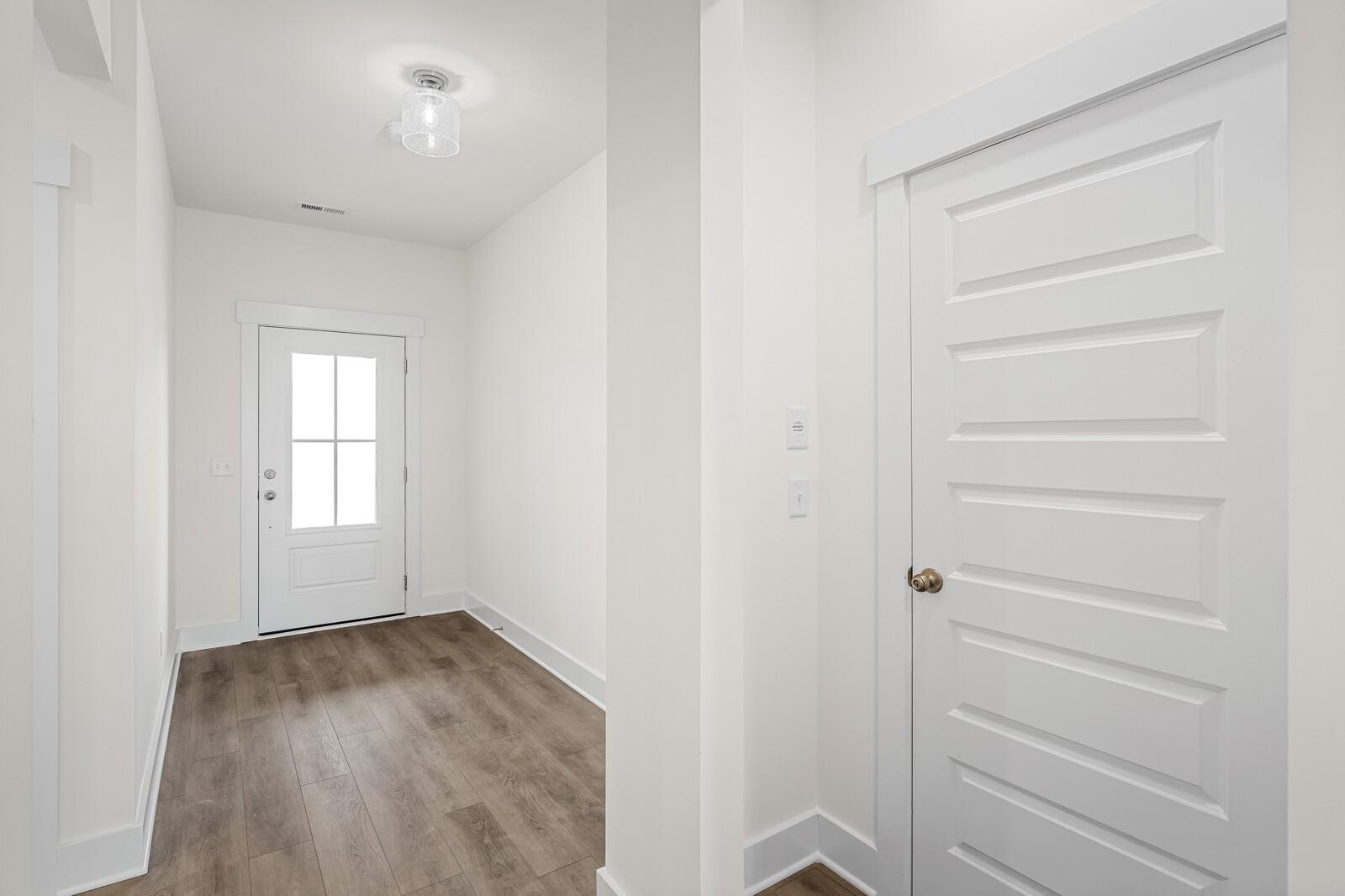 Bright entryway with white door and wood-style flooring in The Ridgeport D floor plan at Benders Cove, Mt. Juliet, TN.