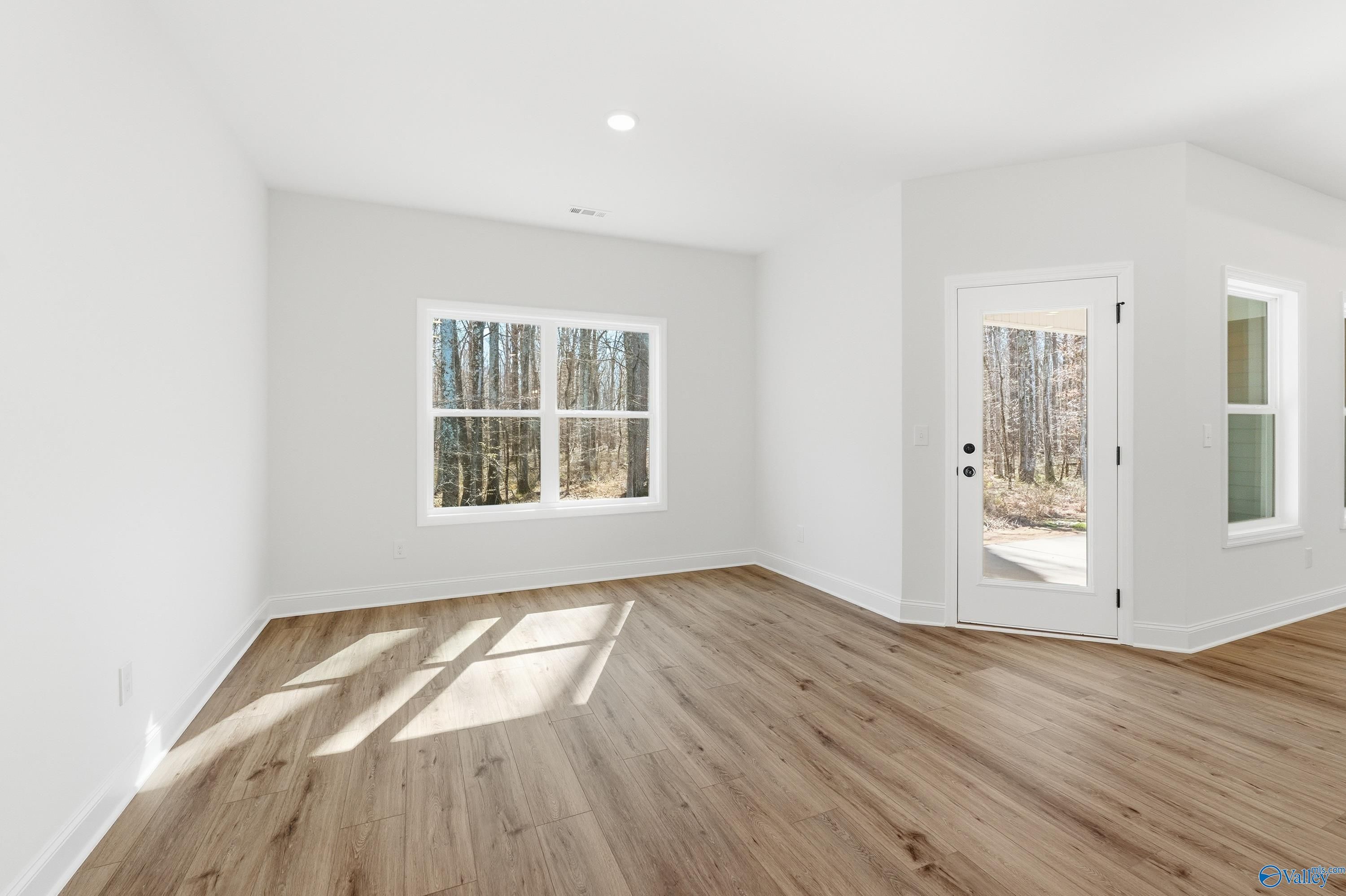 Bright bedroom with hardwood floors, large window overlooking woods, in Davidson Homes The Rockford D, Hazel Green, AL