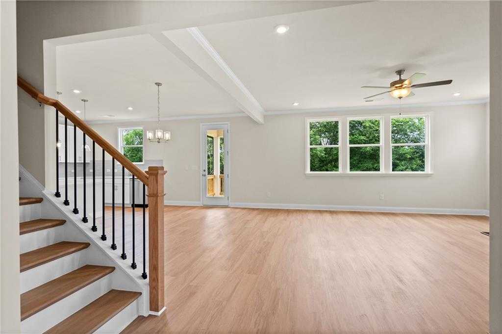 Spacious great room with hardwood floors, oak staircase, large windows and French doors to patio in Davidson Homes The Hickory B at Wehunt Meadows, Hoschton