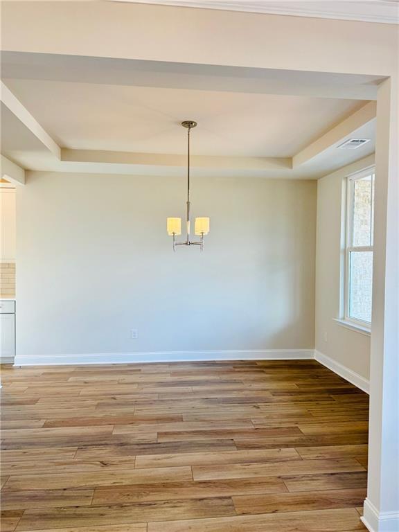 Elegant dining room with hardwood floors, chandelier, and natural light in The Danbury C home, Buford, GA
