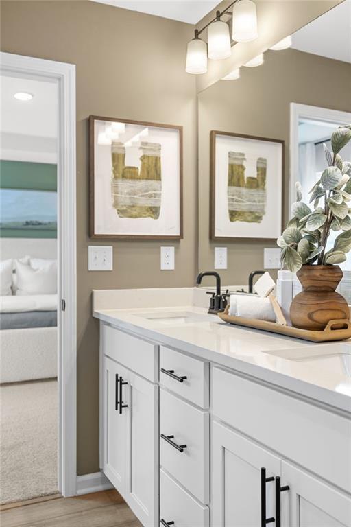 Modern bathroom vanity with white cabinets, quartz countertops, and black fixtures in The Rabun B home at The Bluffs, Canton.