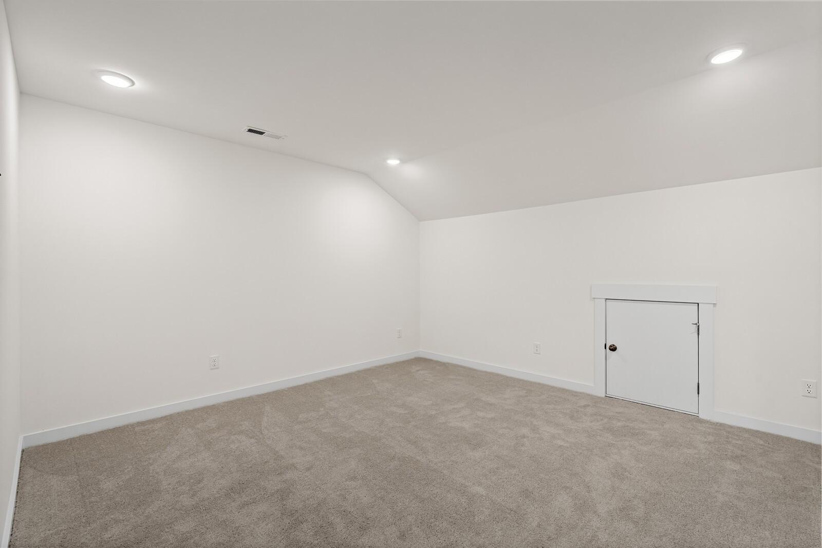 Spacious attic bonus room with carpet and walk-in storage access in The Ridgeport D floor plan, Mt. Juliet, Tennessee.