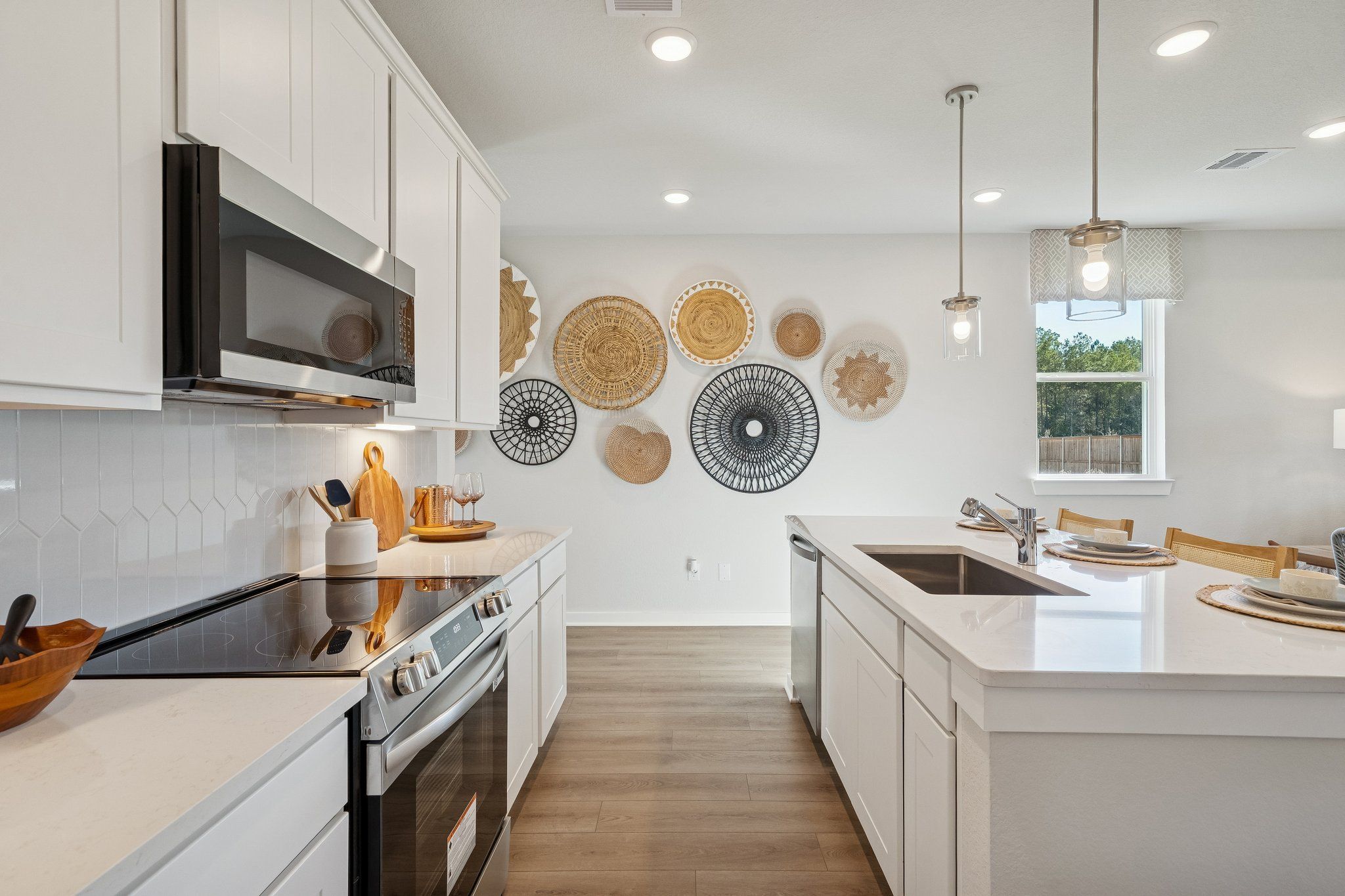 Spacious modern kitchen in Spring Branch Crossing Conroe TX with white shaker cabinets, woven wall art, quartz counters, and hardwood floors