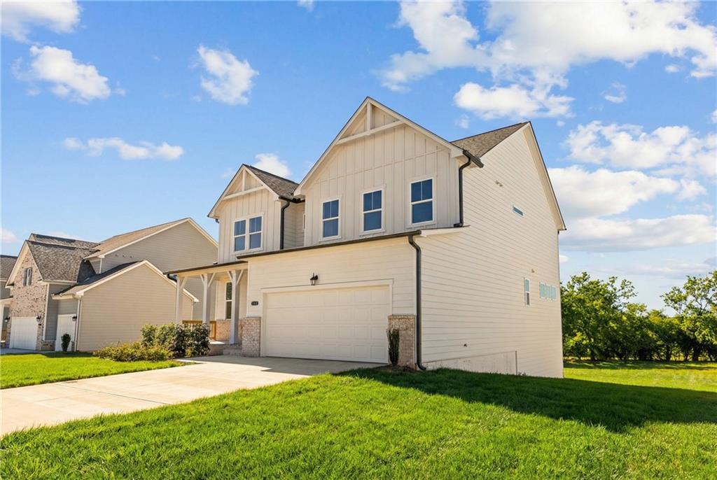 Modern 3-story white home with 2-car garage, gabled roof, and green lawn in Wehunt Meadows, Hoschton, Georgia by Davidson Homes