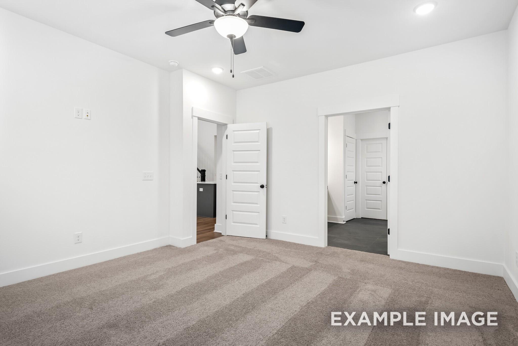 Spacious bedroom with ceiling fan, beige carpet, and en-suite bath in Davidson Homes Ridgeport C, Gallatin, TN