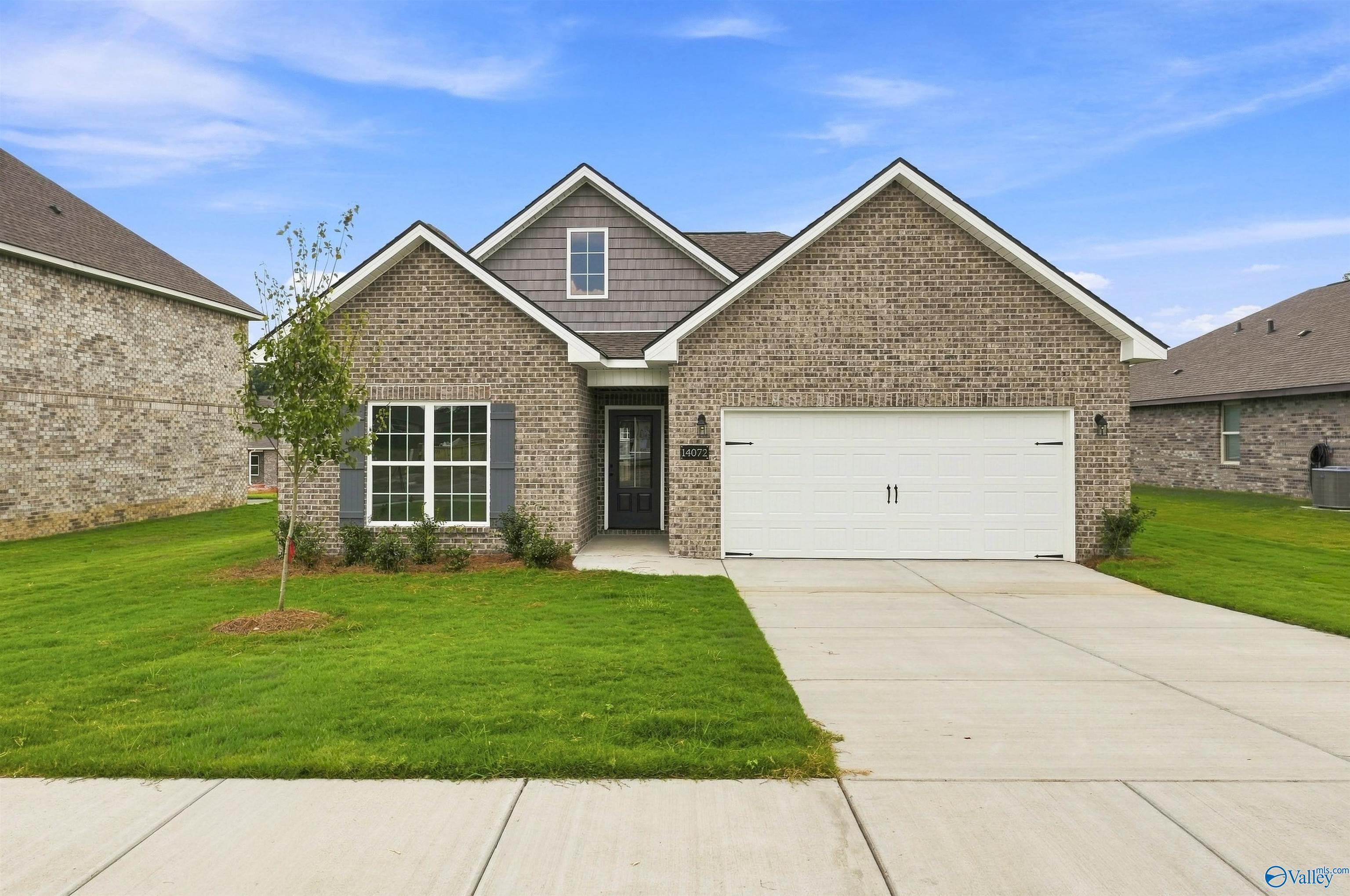 Brick front exterior with 2-car garage and landscaped yard at The Franklin C, a 3-bedroom Davidson home in The Meadows, Athens, AL