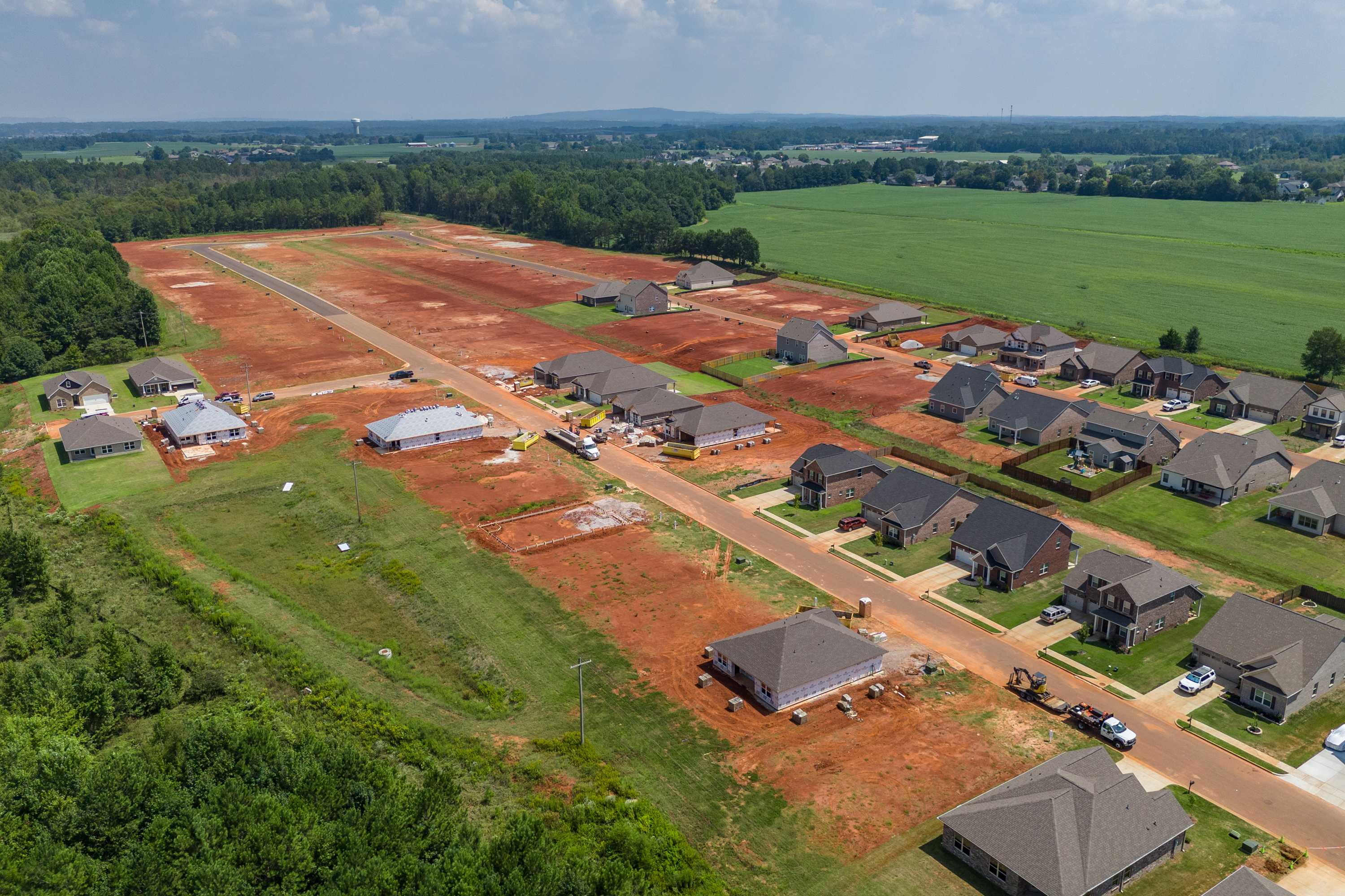 Aerial view of Ricketts Farm construction in Athens Alabama with new Davidson Homes, red clay lots and surrounding fields