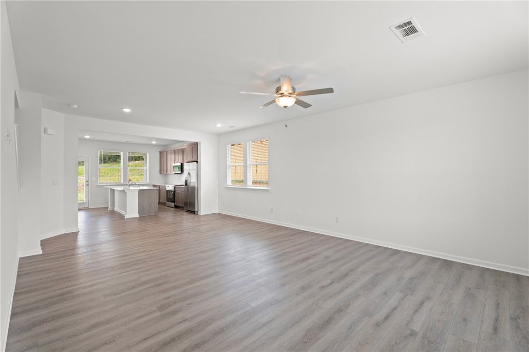 Open-concept living room and kitchen in The Stella D floor plan by Evermore Homes at Silver Oak in Cusseta, Alabama.