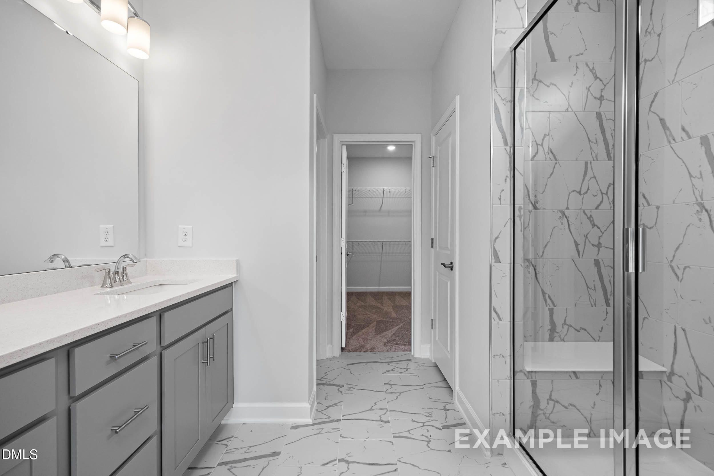 Modern master bathroom with frameless glass shower, white subway tile, double vanity, gray cabinets in Davidson Homes The Ash B, Lillington, NC