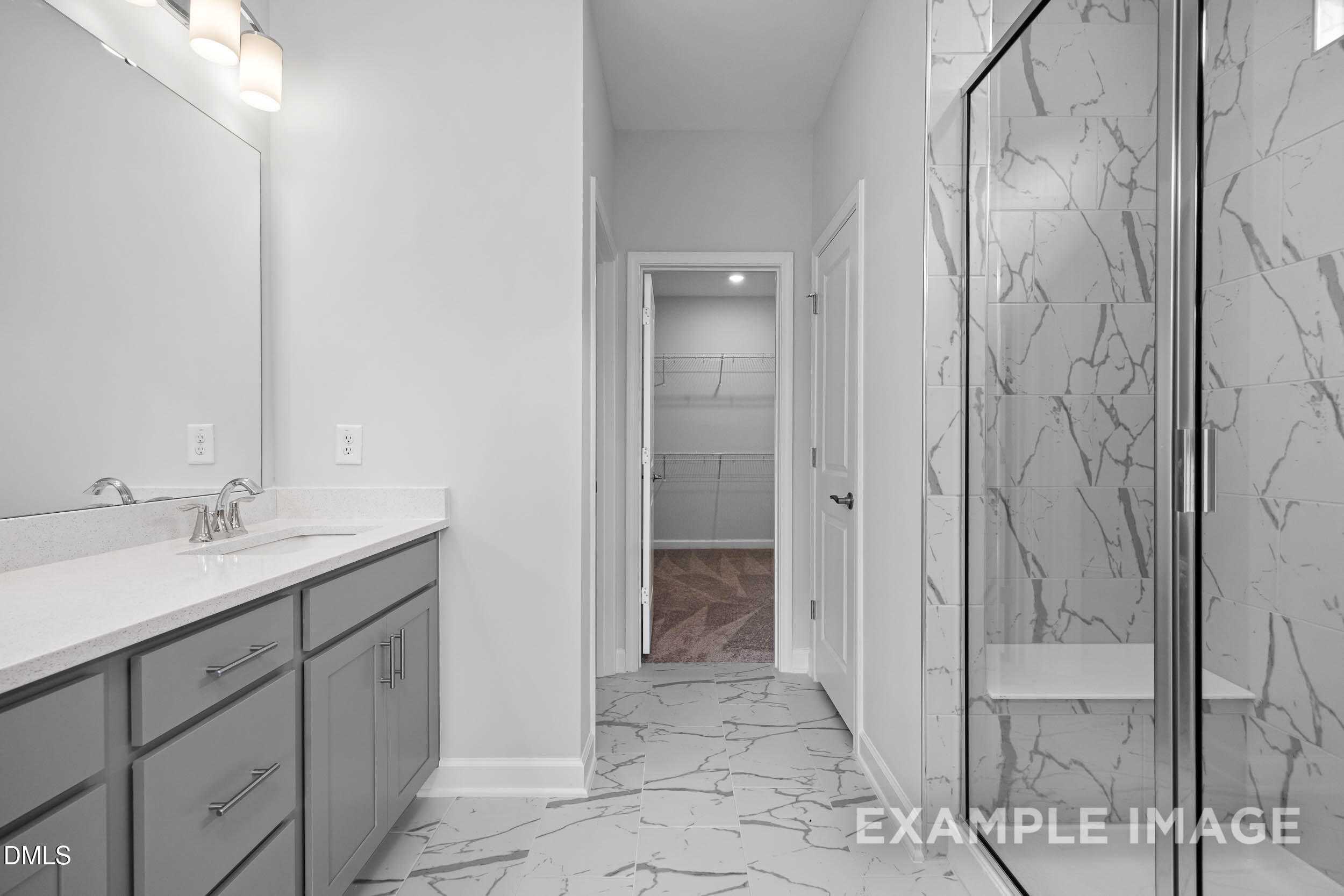 Modern master bathroom with frameless glass shower, white subway tile, double vanity, gray cabinets in Davidson Homes The Ash B, Lillington, NC