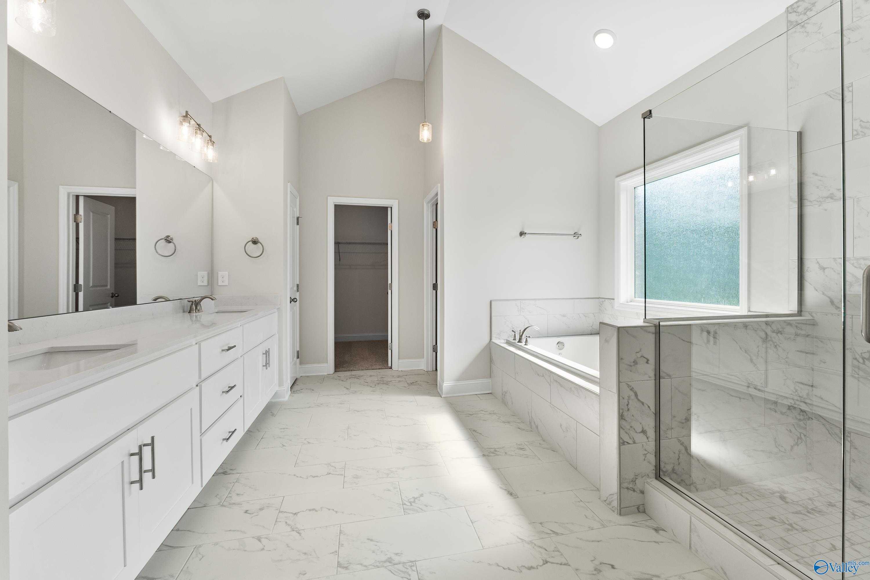 Luxurious master bathroom with marble double vanity, freestanding tub, and frameless glass shower in Davidson Homes The Finleigh, Toney, Alabama