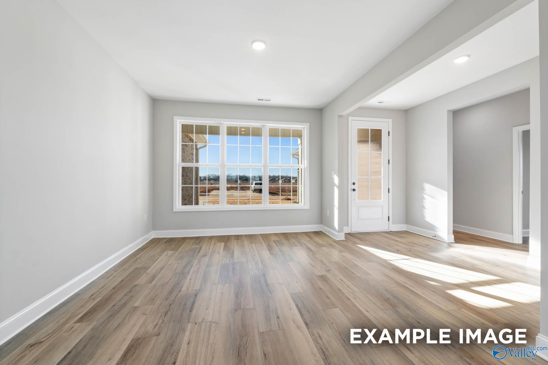 Bright great room with hardwood floors, large windows, and French doors to outdoors in Davidson Homes The Valencia, Toney Alabama