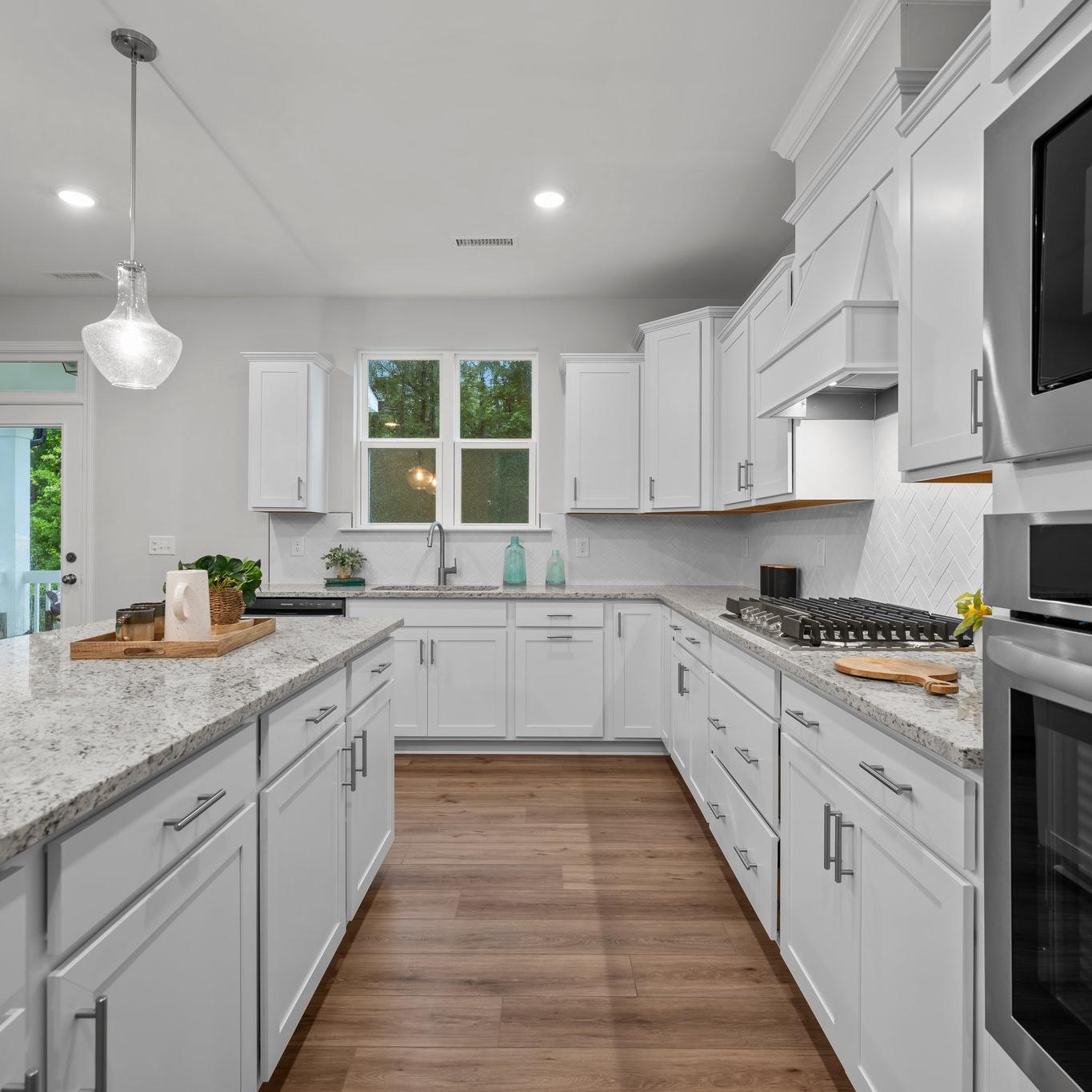 Spacious modern kitchen in Montrose Aberdeen NC with white shaker cabinets, quartz island, stainless appliances, pendant lights, French doors