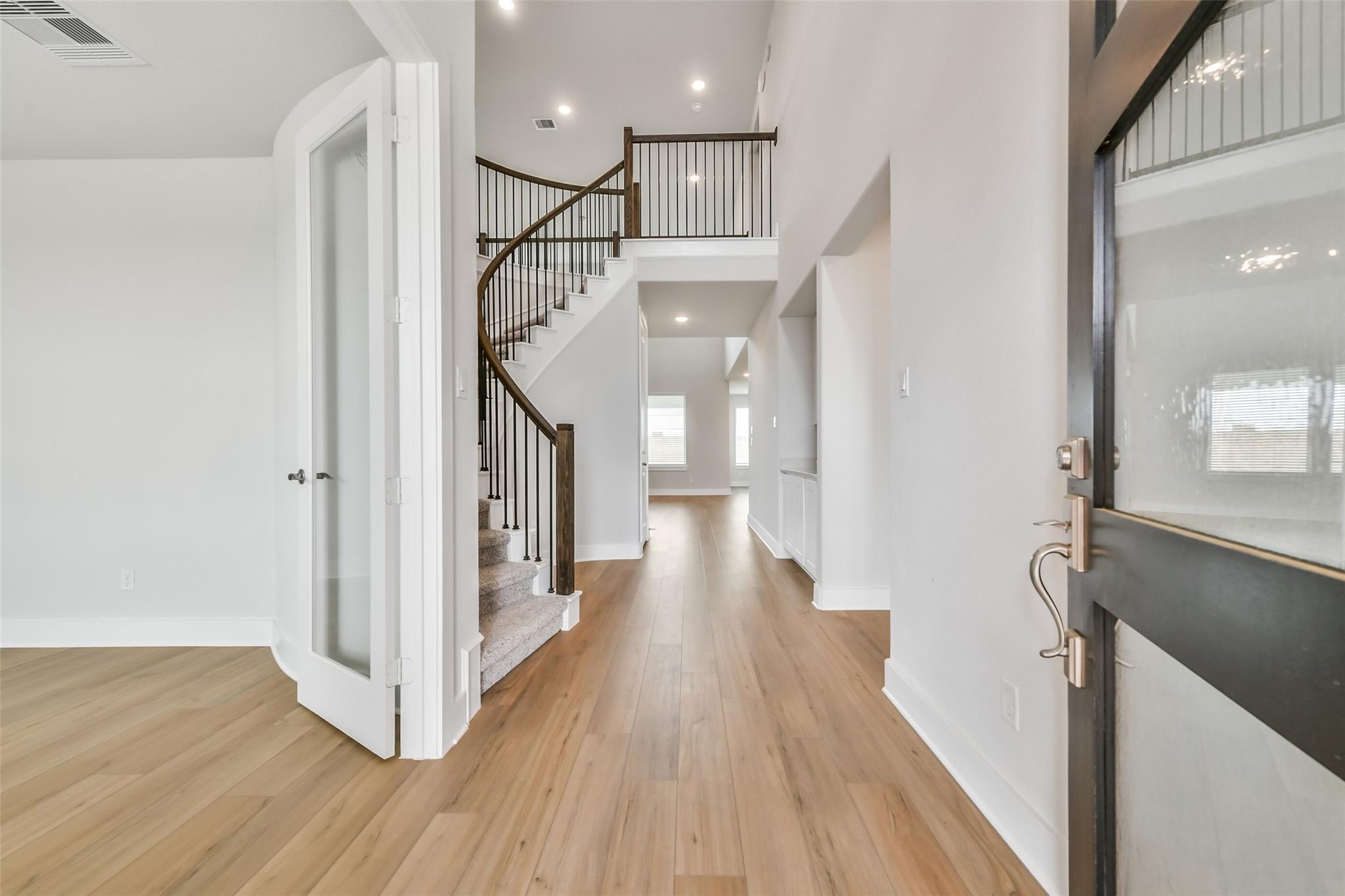 Grand curved wooden staircase in open foyer with hardwood floors, Davidson Homes The Victoria A, Lago Mar, Texas City
