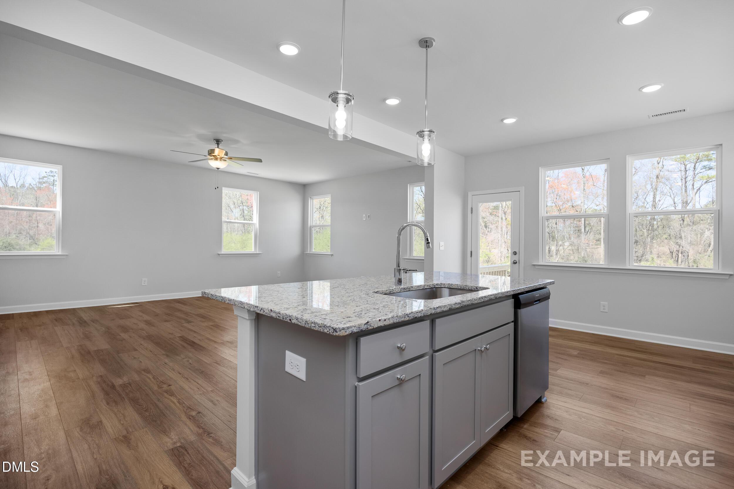 Open-concept kitchen with granite island in The Gavin A floor plan by Davidson Homes in Gregory Village, Lillington, NC.
