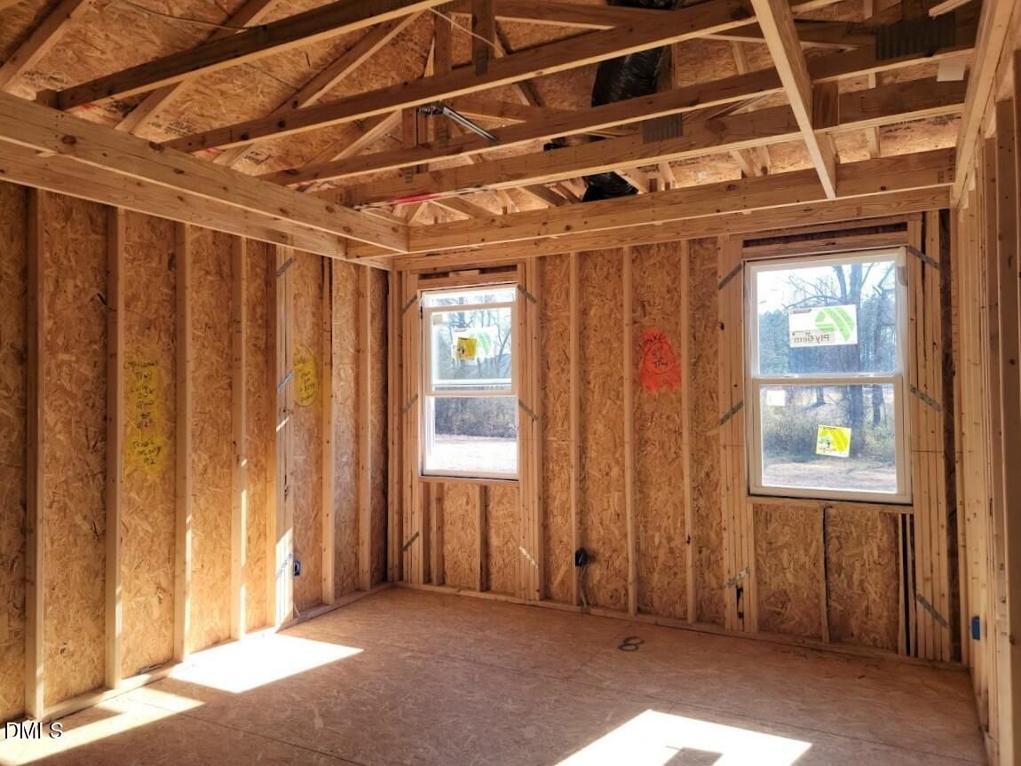 Exposed wooden framing with large windows and natural light in unfinished room of Davidson Homes Ashport G, Angier, NC