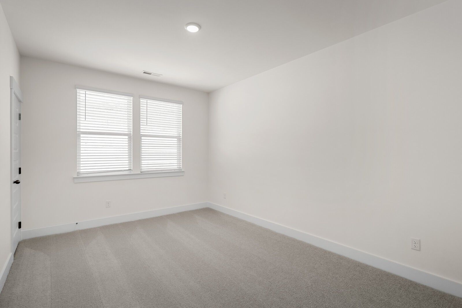 Bright, carpeted bedroom with neutral walls in The Willow floor plan by Davidson Homes in Woods Crossing, Gallatin, TN.