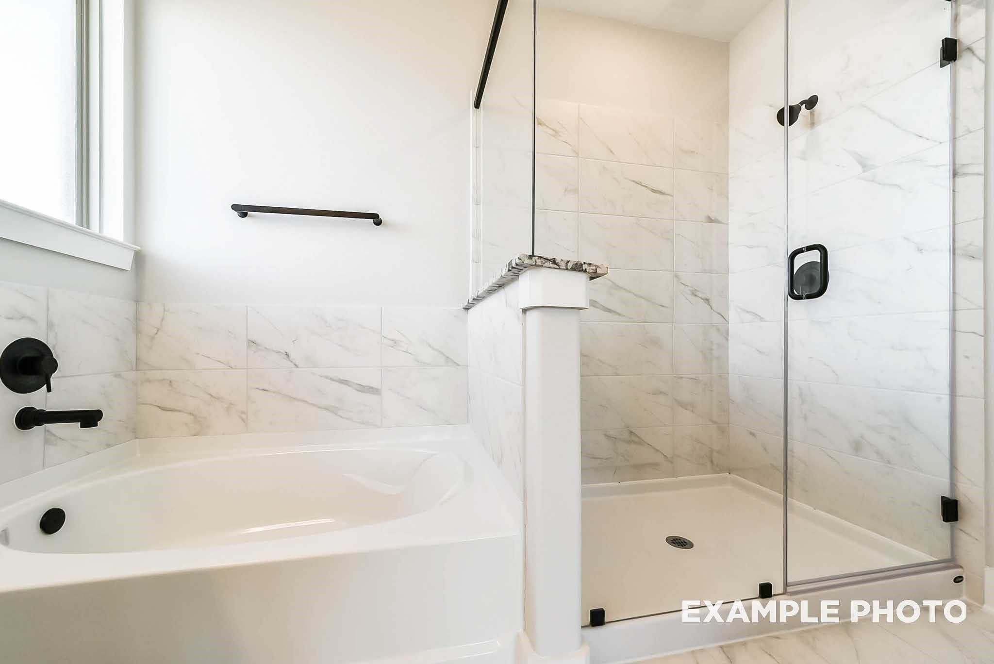 Modern master bathroom featuring soaking tub, frameless glass shower, white subway tiles in Davidson Homes The Philip C, Rosharon, Texas