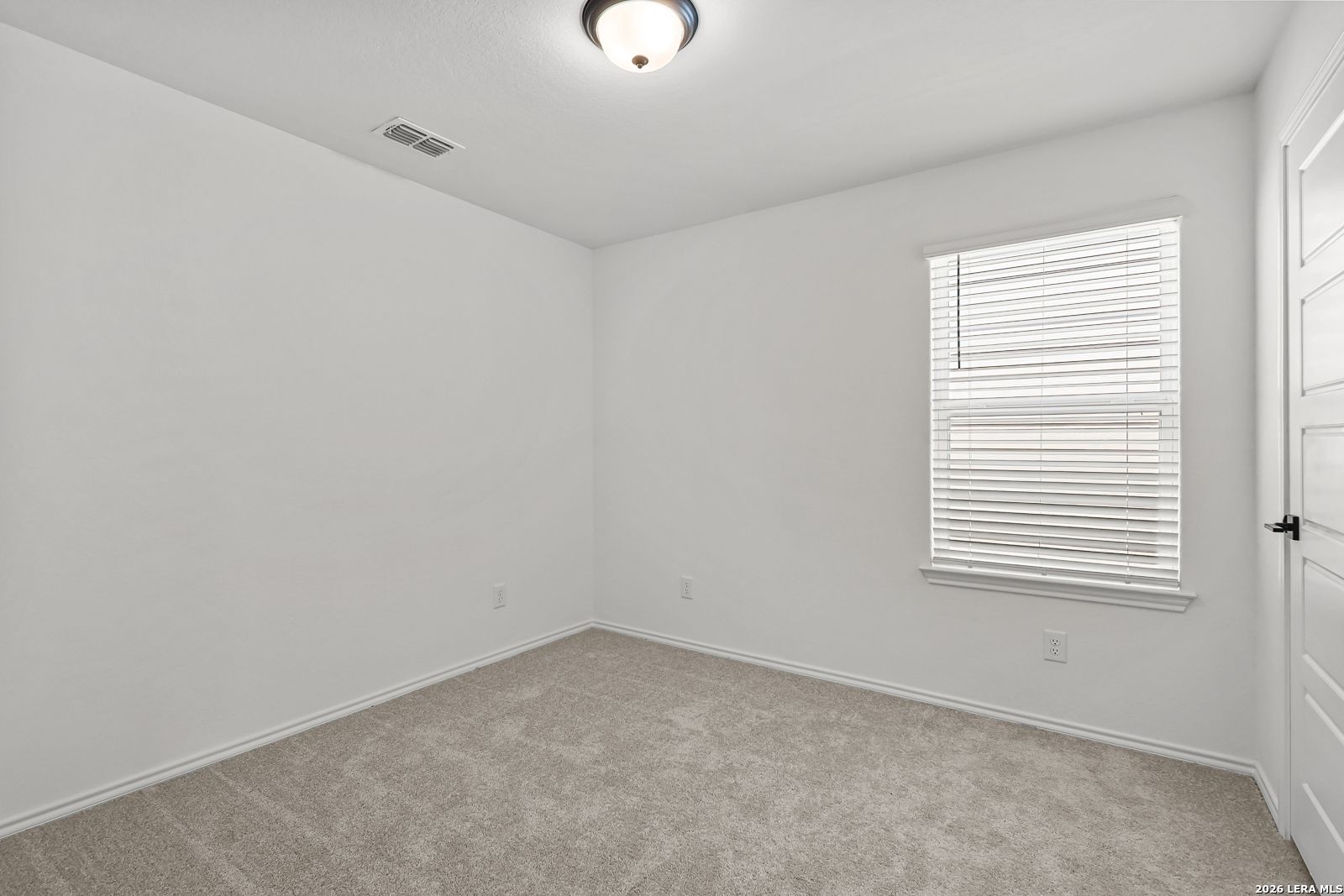 Bright bedroom with carpet and window blinds in The Gillian C floor plan by Davidson Homes in San Antonio, Texas.