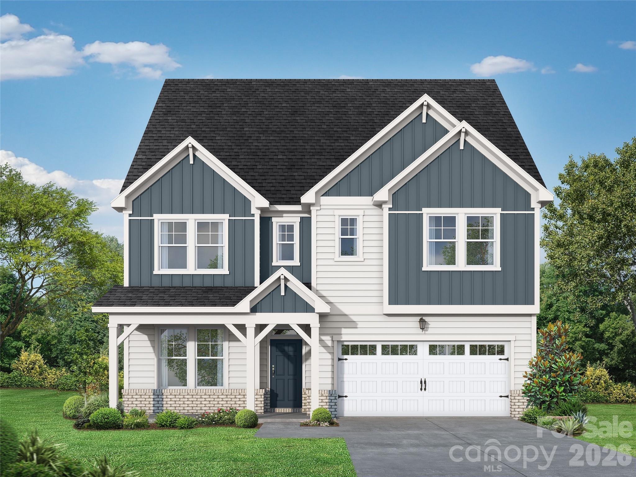 Modern gray craftsman home with shiplap siding, front porch, 2-car garage, lush landscaping in Enclave at Belmont, North Carolina
