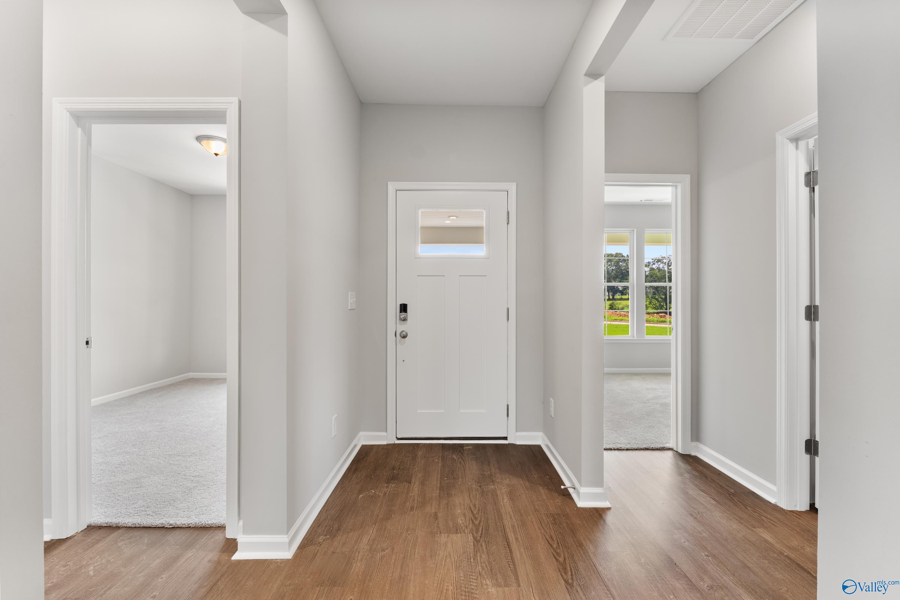 Welcoming entry foyer with hardwood floors, neutral walls, and frosted glass door in Davidson Homes The Sanctuary, Huntsville AL