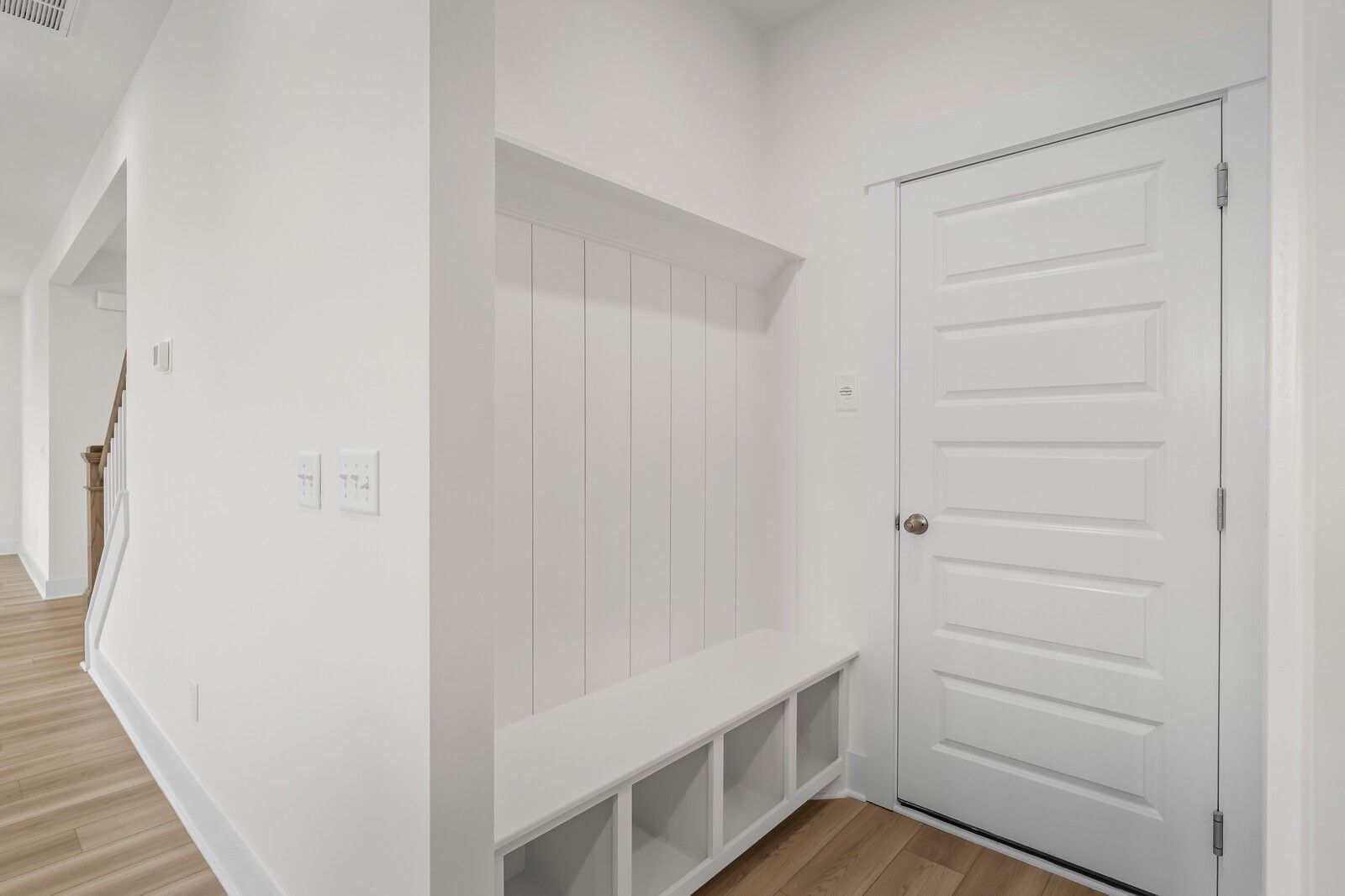 Built-in mudroom bench with white shiplap and storage cubbies in Davidson Homes The Henry C floor plan, Mt. Juliet, TN.