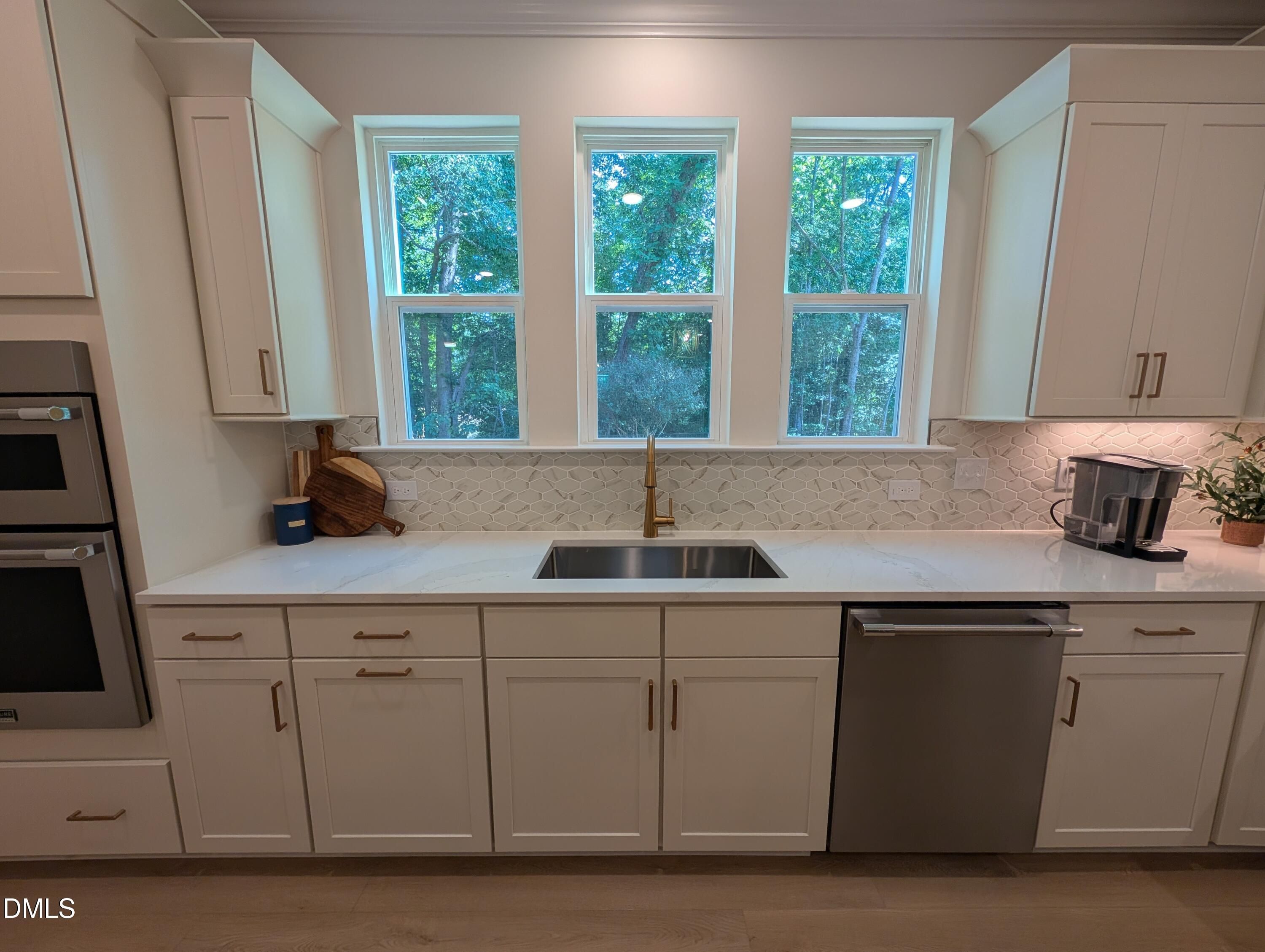 Modern kitchen sink with gold faucet and tile backsplash in The Aspen B floor plan by Davidson Homes in Wendell, NC.