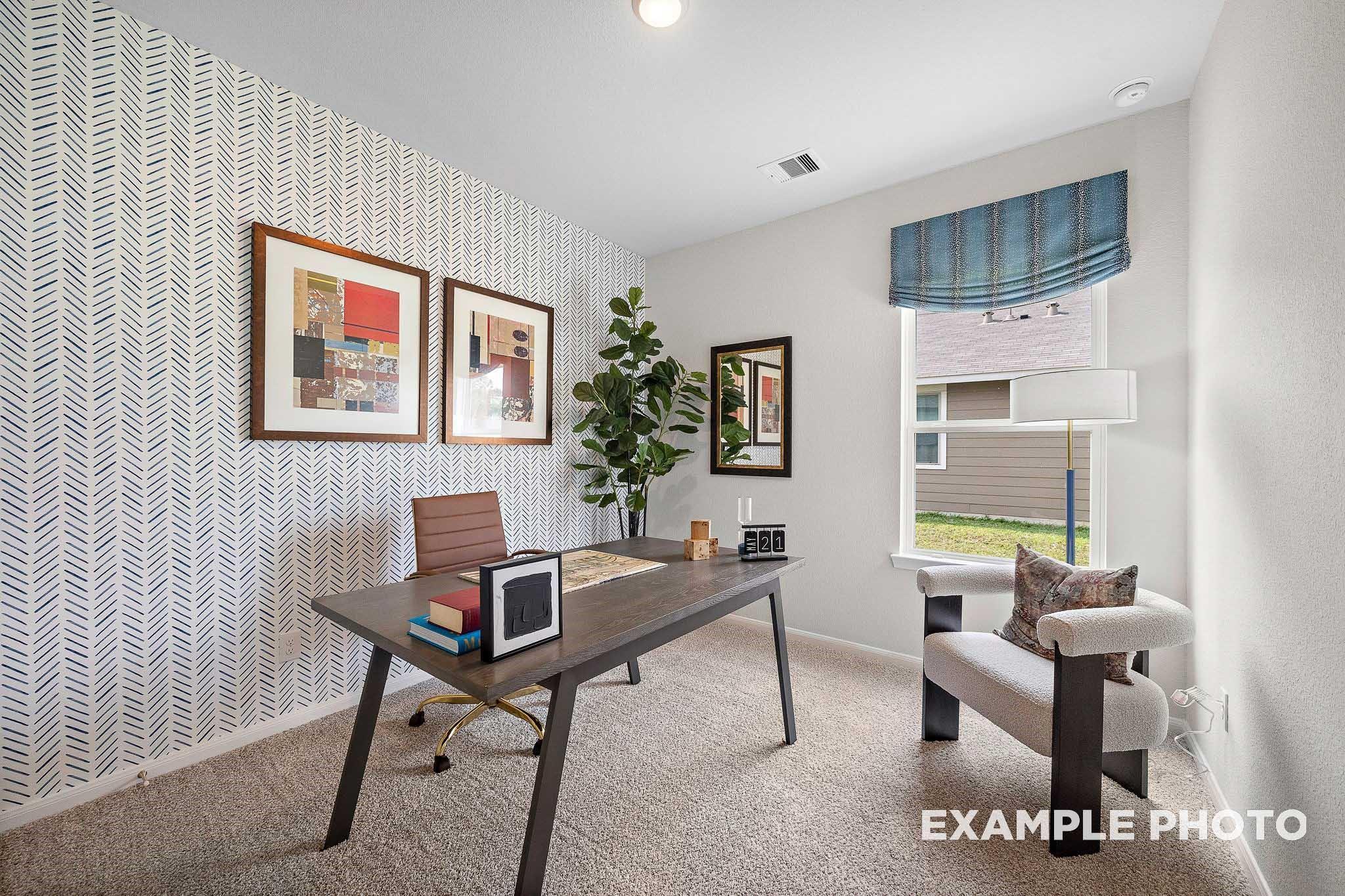 Cozy home office with chevron wallpaper, wooden desk, leather chair, potted fiddle leaf fig, and window in Davidson Homes San Marcos E, Conroe Texas