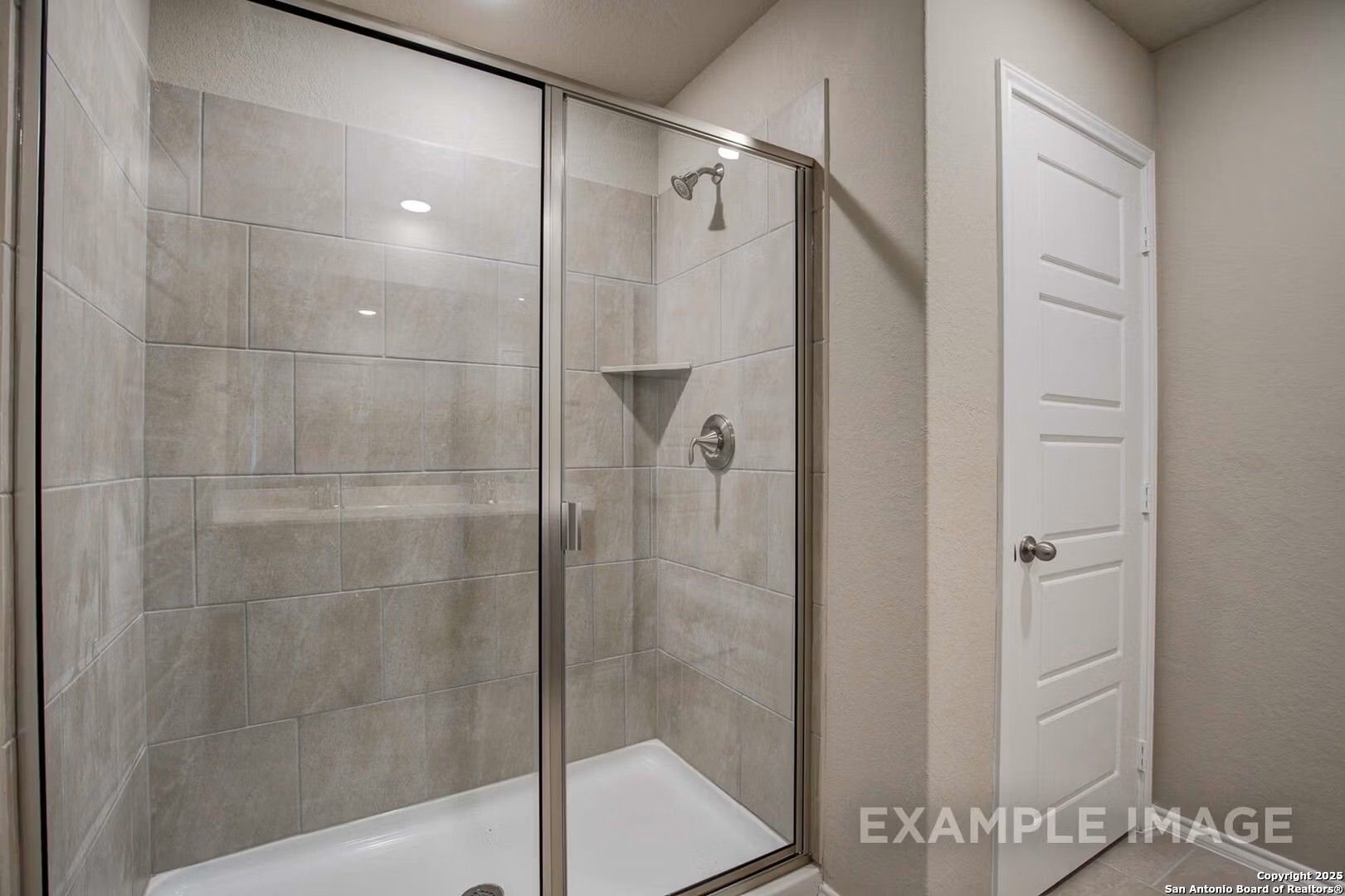 Modern walk-in shower with frameless glass enclosure and gray subway tile walls in master bath, Davidson Homes The Murray K, San Antonio