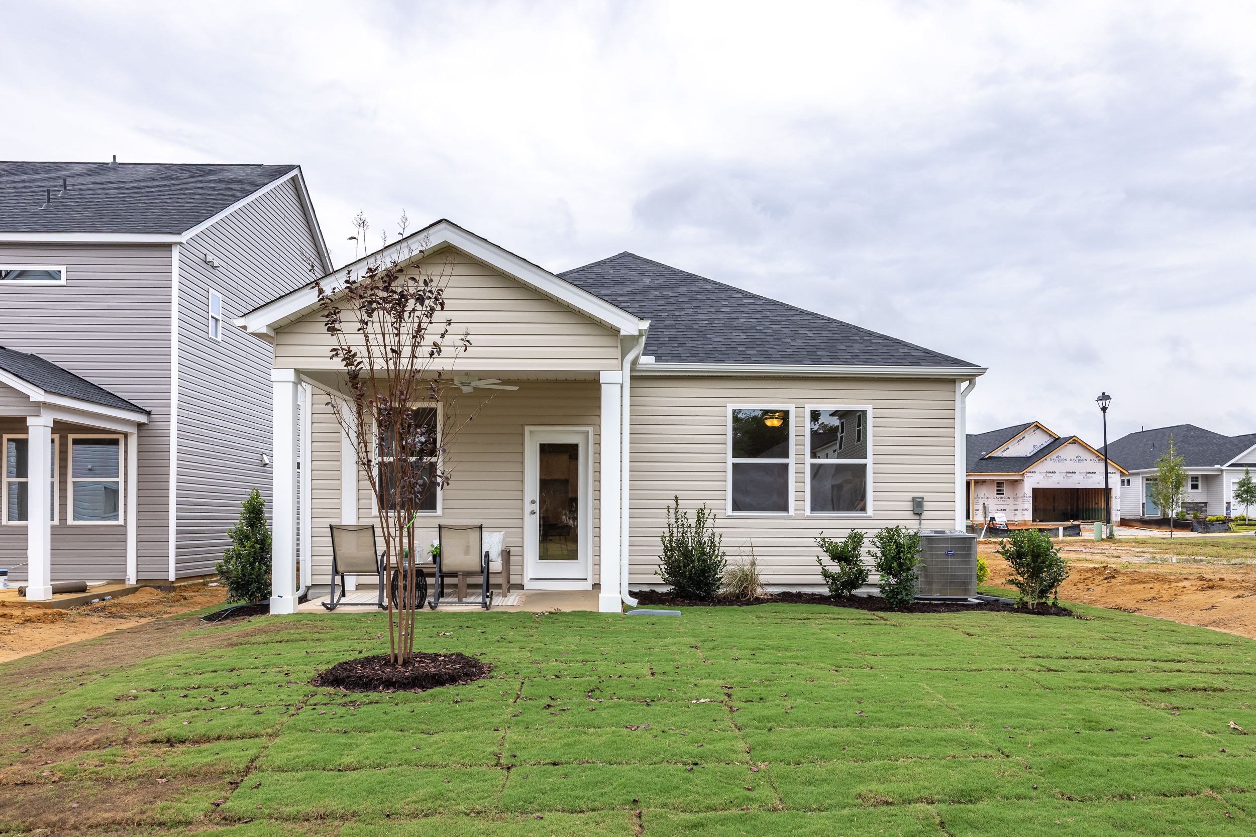 Tan siding exterior of a Davidson Homes house at Gregory Village in Lillington, NC with a covered back patio.