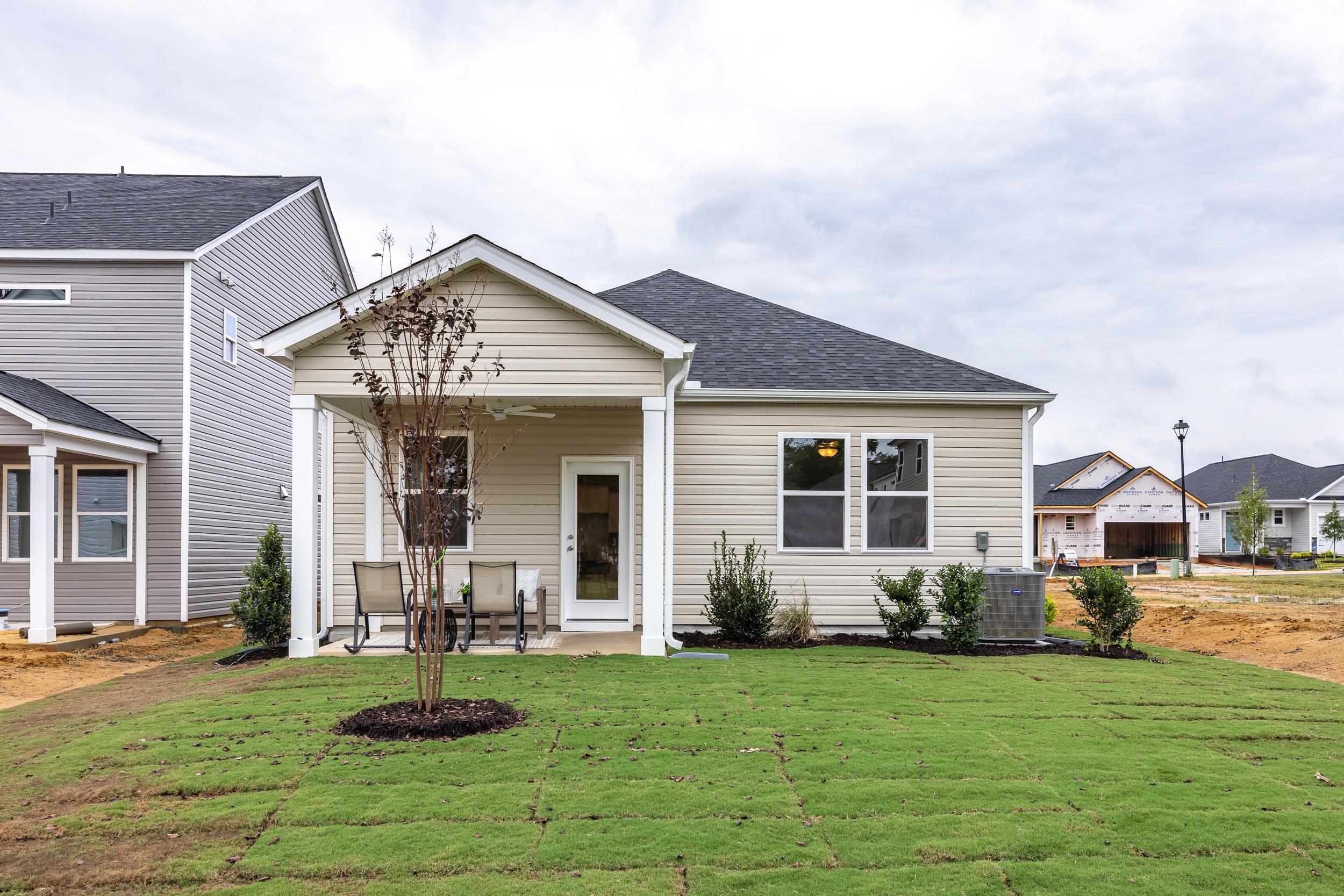 Tan siding exterior of a Davidson Homes house at Gregory Village in Lillington, NC with a covered back patio.