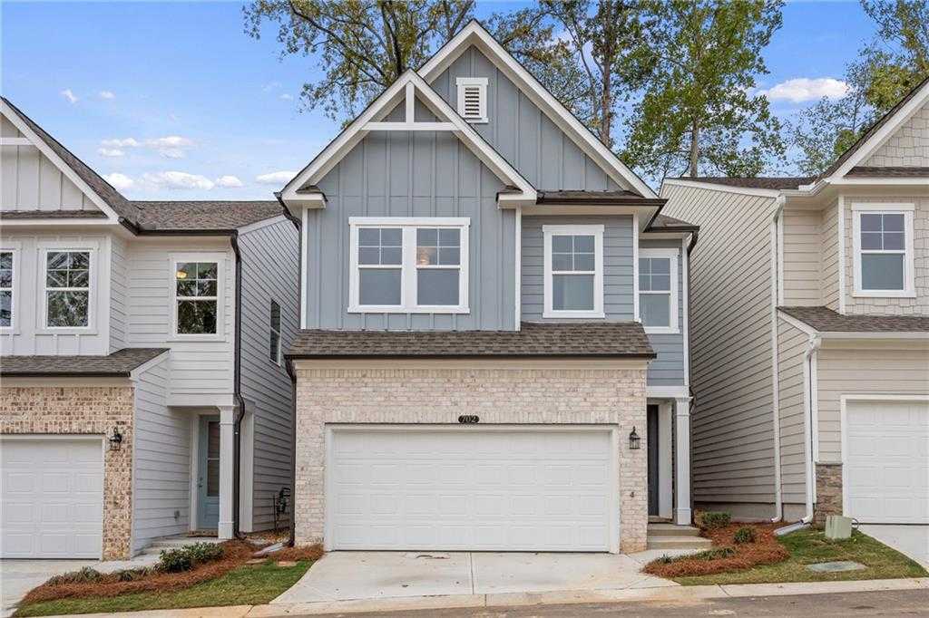 Modern two-story blue home with two-car brick garage, driveway, and landscaping in The Village at Shallowford, Kennesaw, Georgia