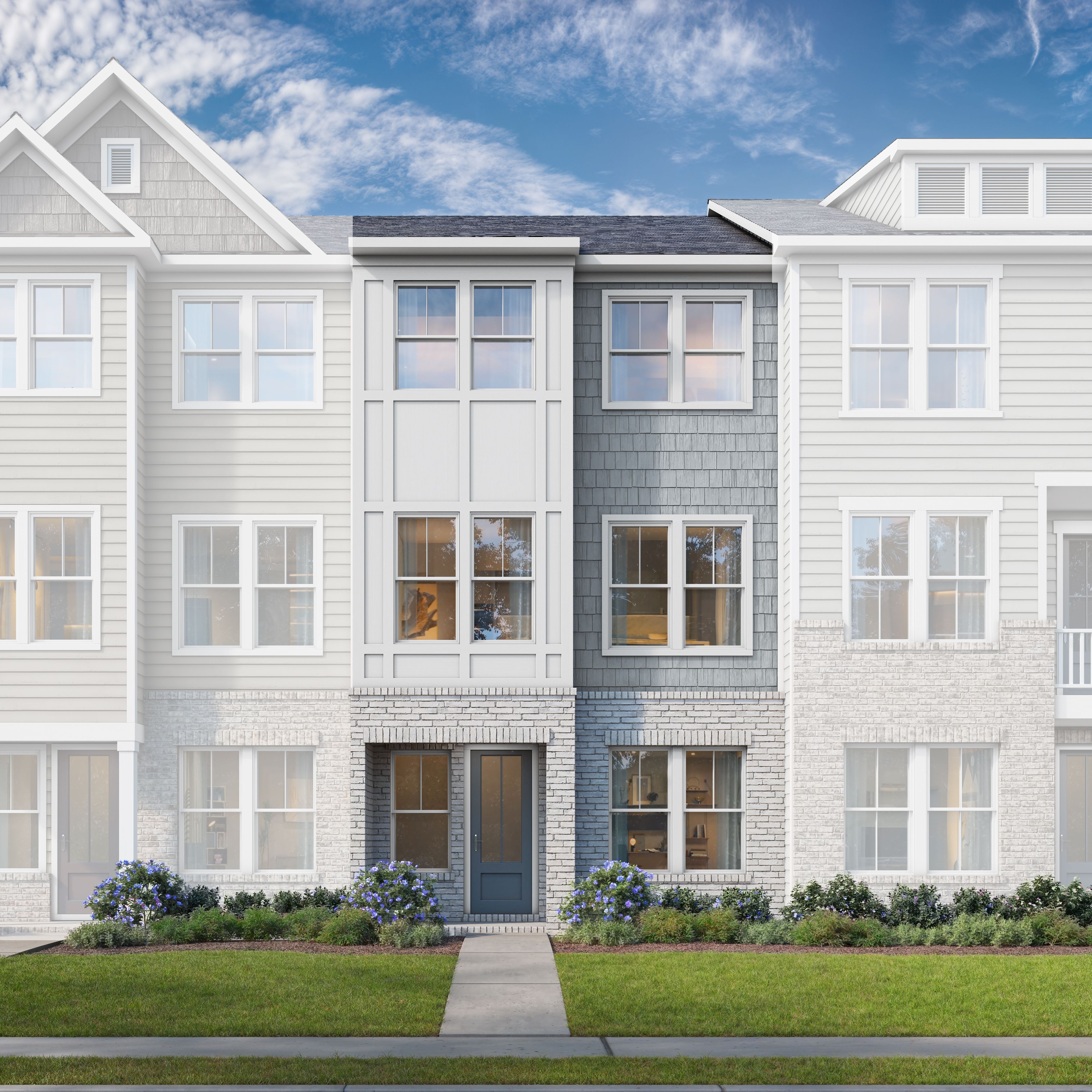 Modern 3-story townhome elevation of The Lincoln C with white siding, gray accents, brick base, and landscaped front yard in Woodstock, GA