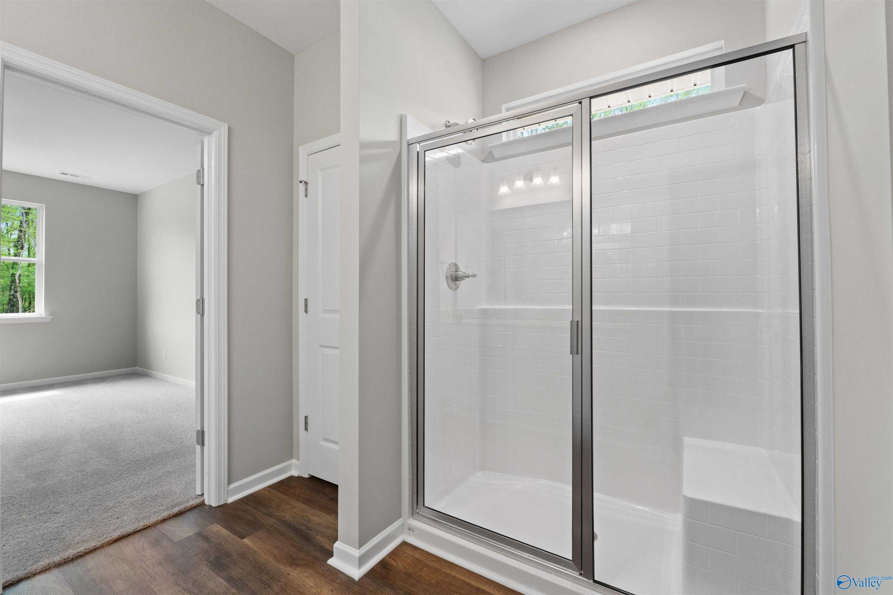 Modern master bathroom with frameless glass shower and white subway tile in Davidson Homes The Luna, Hazel Green, Alabama