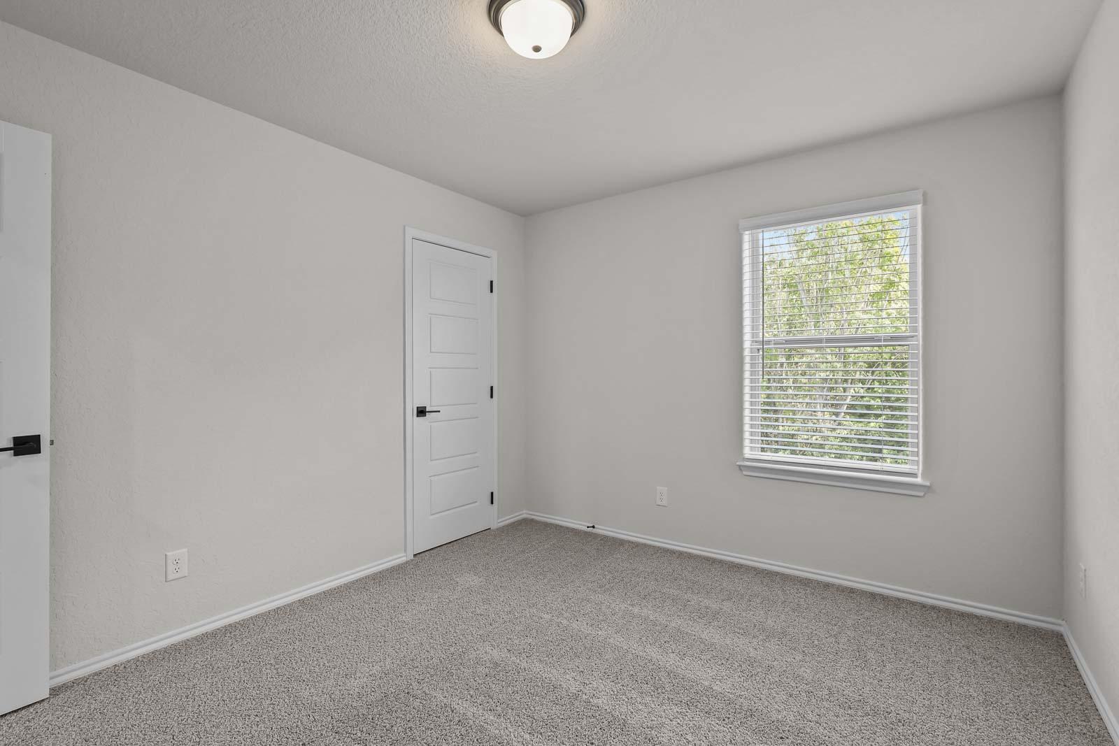 Bright, spacious bedroom in The Florence B home design by Davidson Homes featuring neutral carpet and natural light.